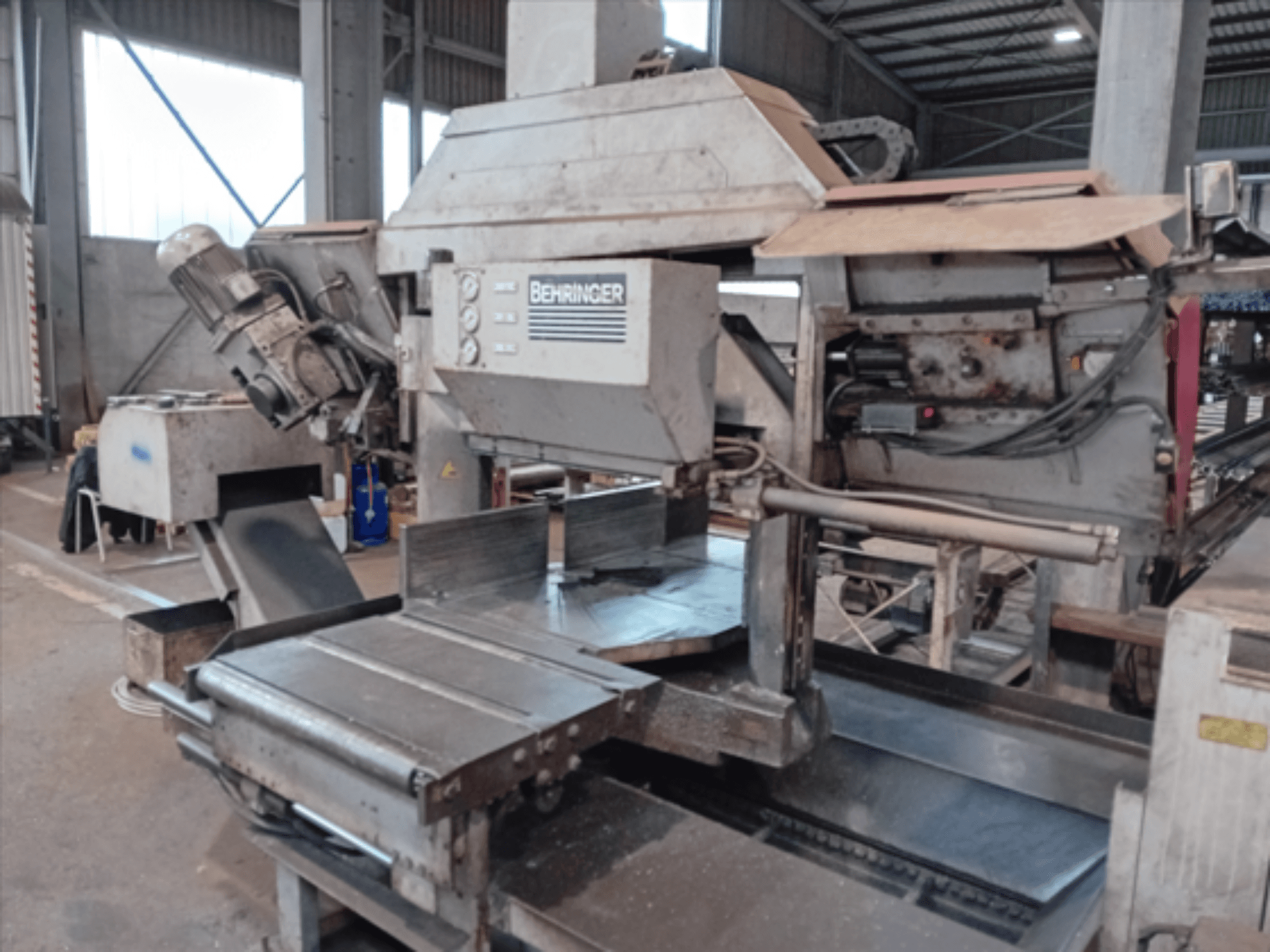 Behringer bandsåg, framifrån, har en stor klinga, motor och justerbart bord, perfekt för metallbearbetning i en verkstad.