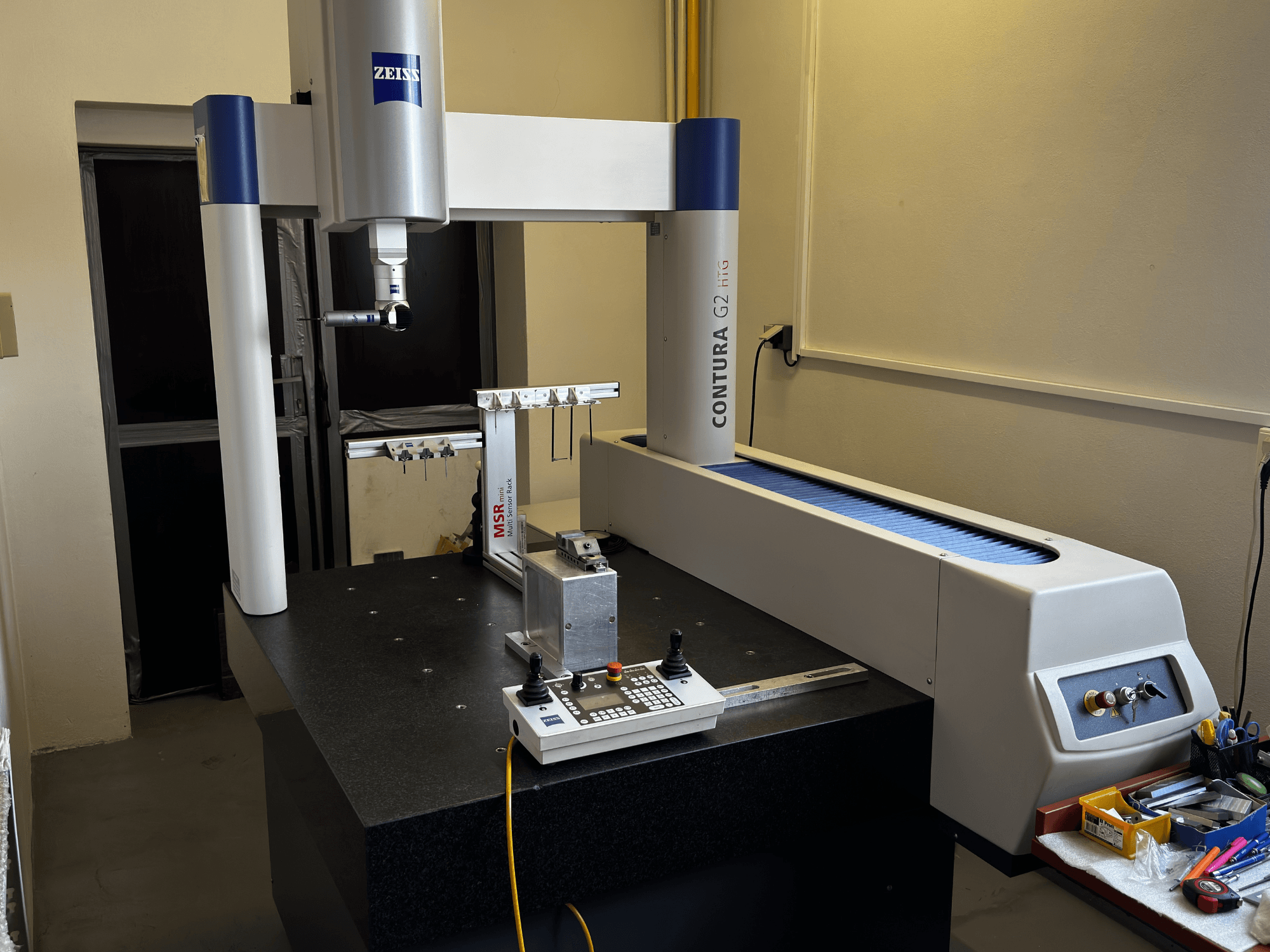 ZEISS Contura G2 CMM i en labbmiljö, framifrån visar mätarmen, kontrollpanelen och intilliggande arbetsyta.