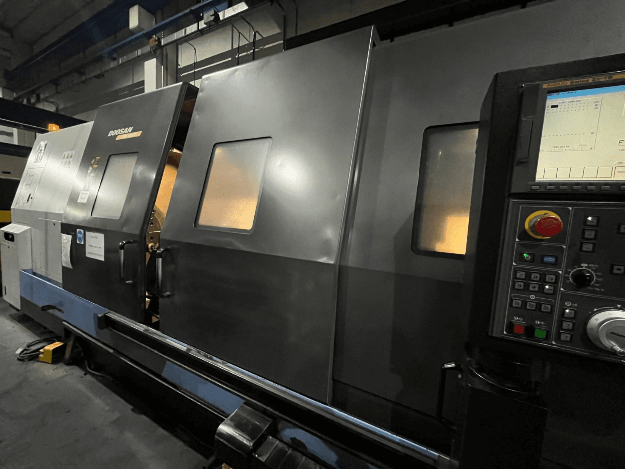 Doosan CNC-svarvmaskin framifrån, med kontrollpanel och operatörsgränssnitt med synlig digital display och knappar.