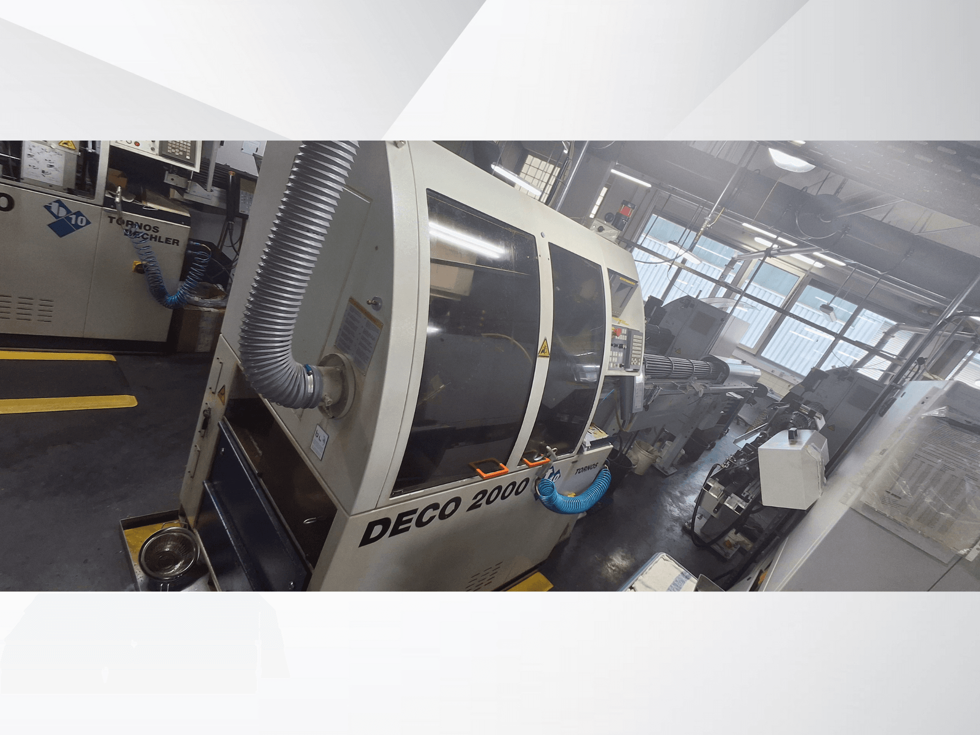 DECO 2000 CNC-maskin i verkstad, vy framifrån, med ventilationsslang och kontrollpanel, konstruerad för precisionsbearbetning.