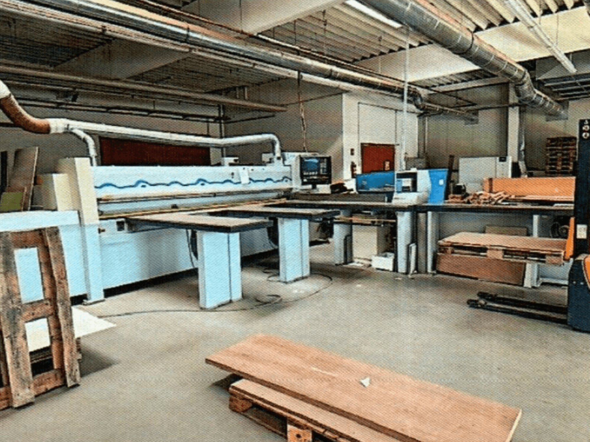 HOMAG HPL 11/38/22 panelsåg i en verkstad med stort kapbord och displaykonsol, sedd framifrån.