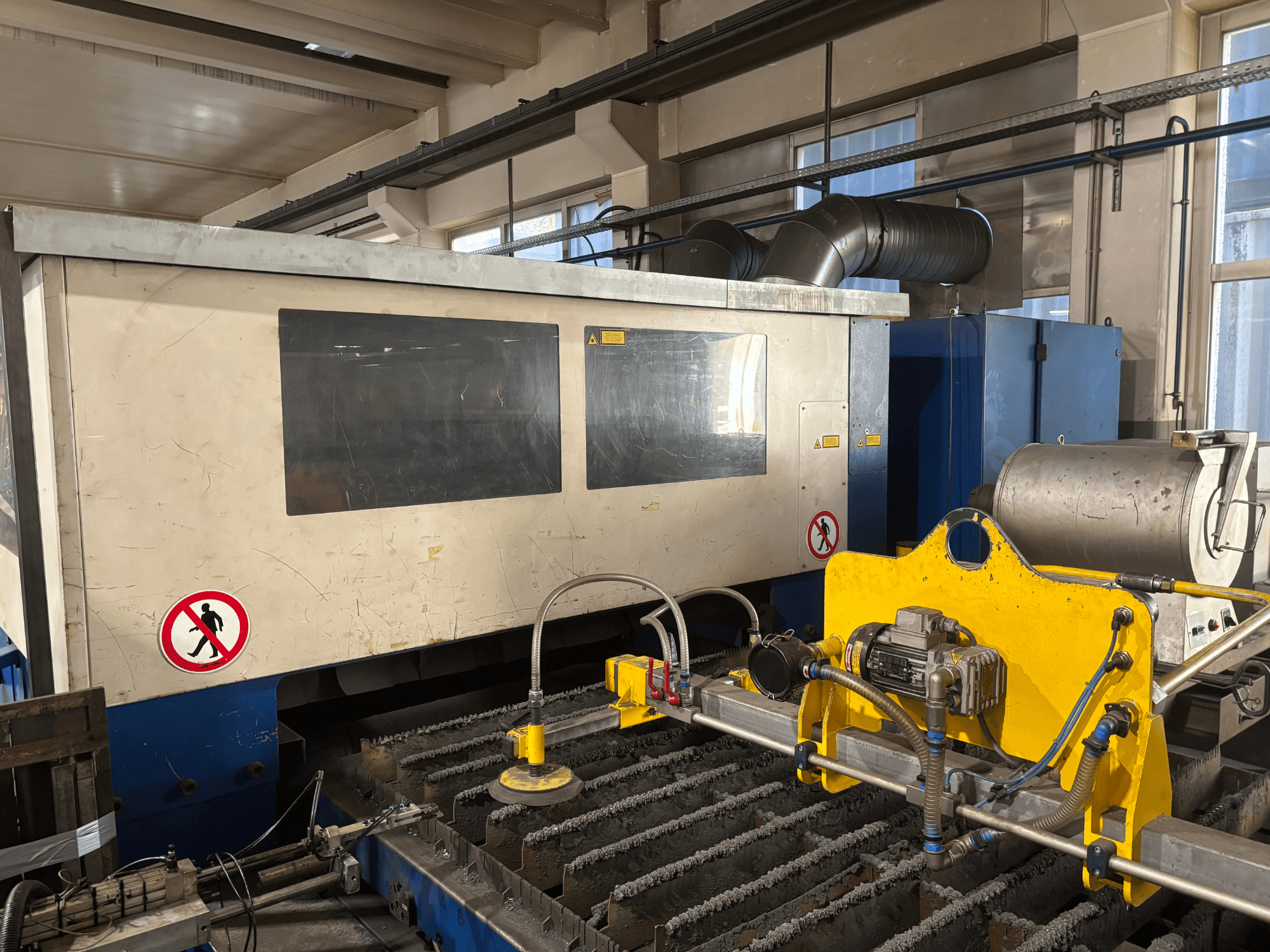 TRUMPF Trumatic L3030 CO2-laserskärmaskin, framifrån med kontrollgränssnitt och detaljer om skärytan.