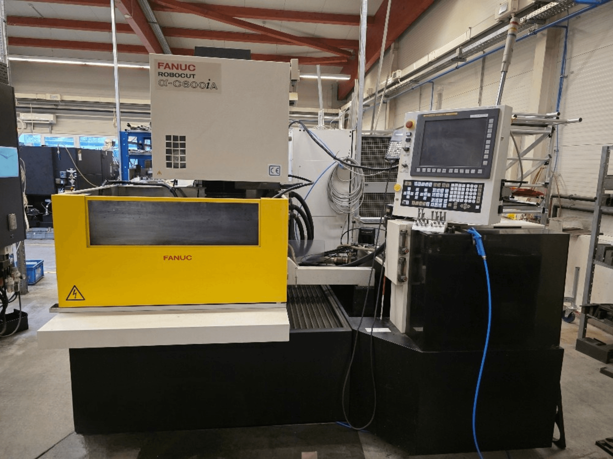 FANUC Robocut α-C600iA trådskärmaskin, framifrån, med gul kontrollpanel och digital display.