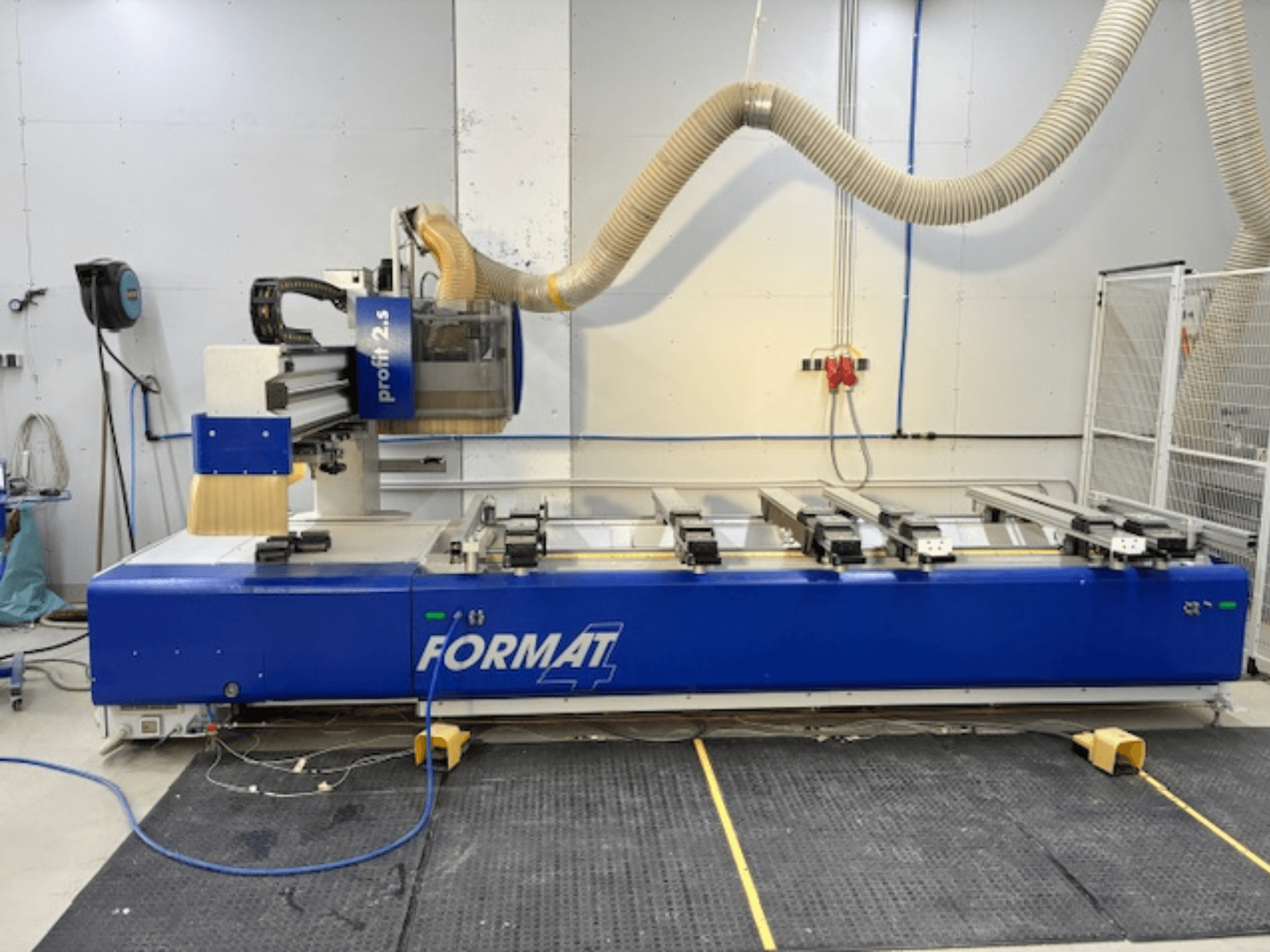 Blue FORMAT 4 CNC-fräs, modell Profit 2.5, sidovy som visar skärområdet och dammutsugningssystemet, på en gummimatta.