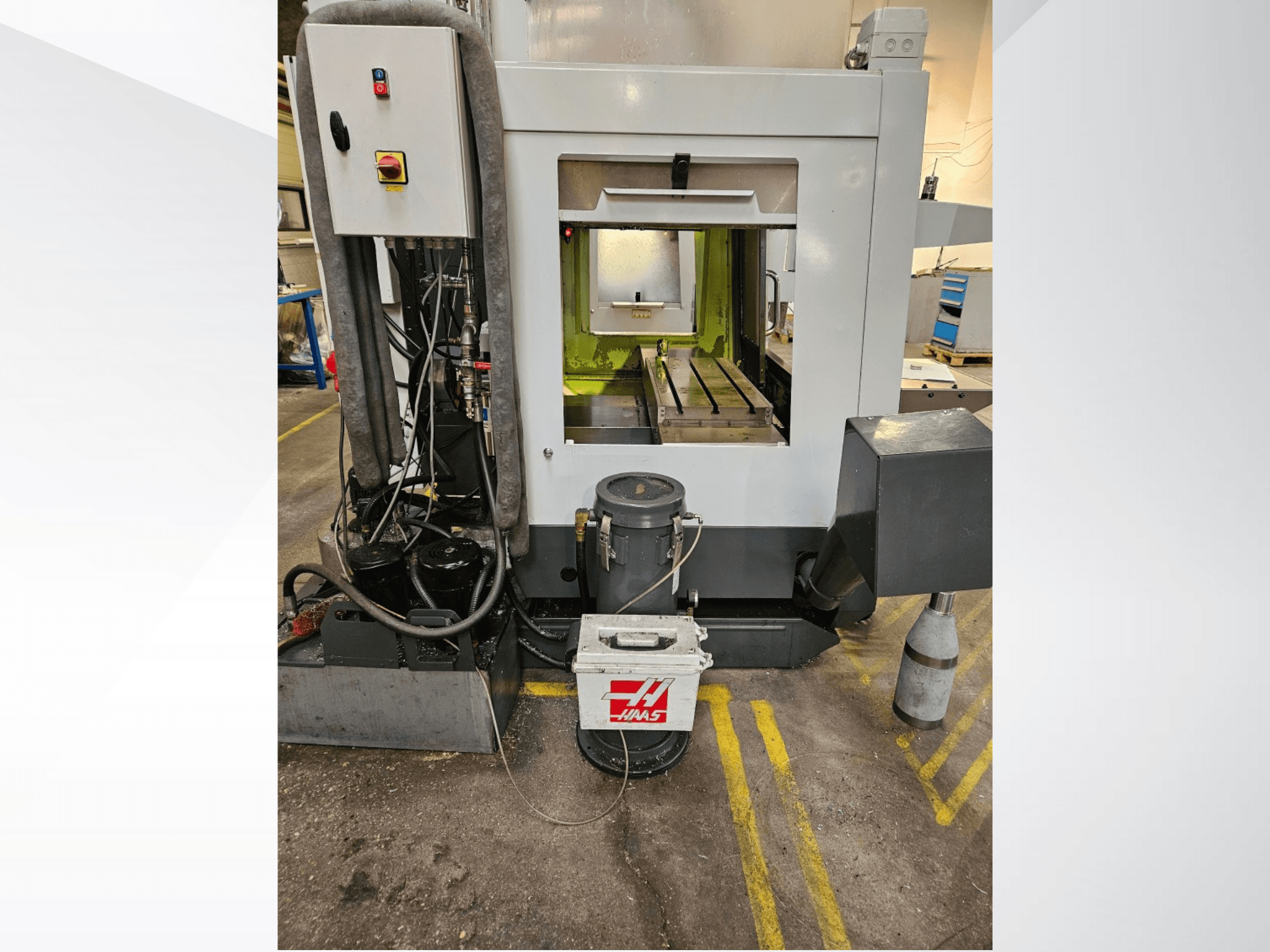 Haas CNC-maskin framifrån med kontrollpanelen, kylvätsketanken och den bearbetade bädden på displayen.