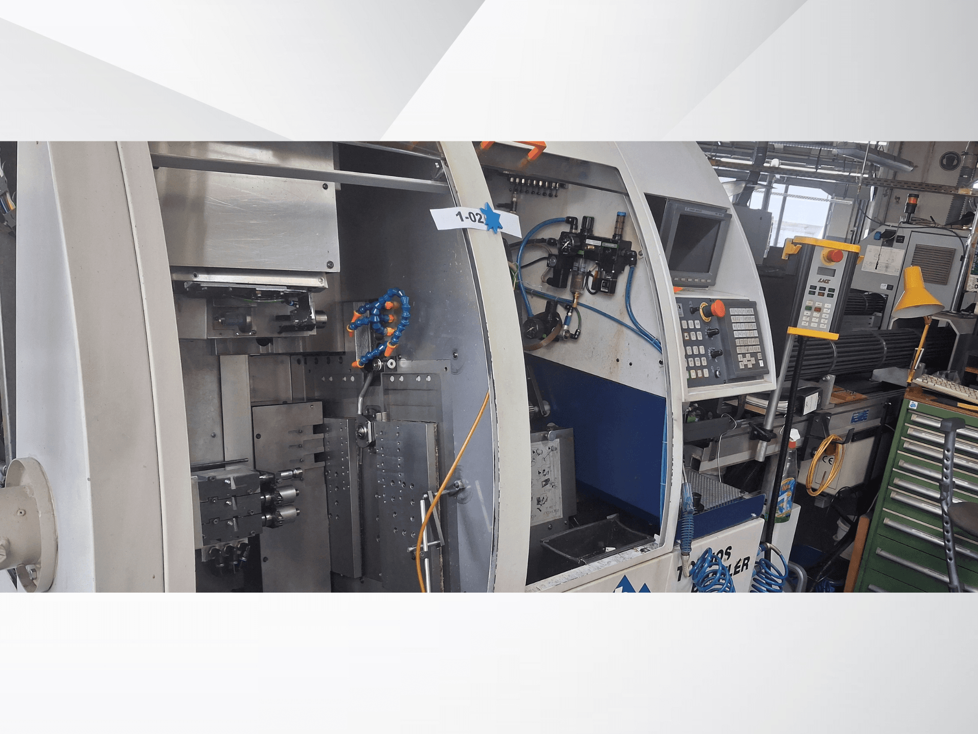 Svarvmaskin av schweizisk typ TORNOS DECO 2000-10, framifrån med kontrollpanel, rotationsmekanism och interna inställningar.