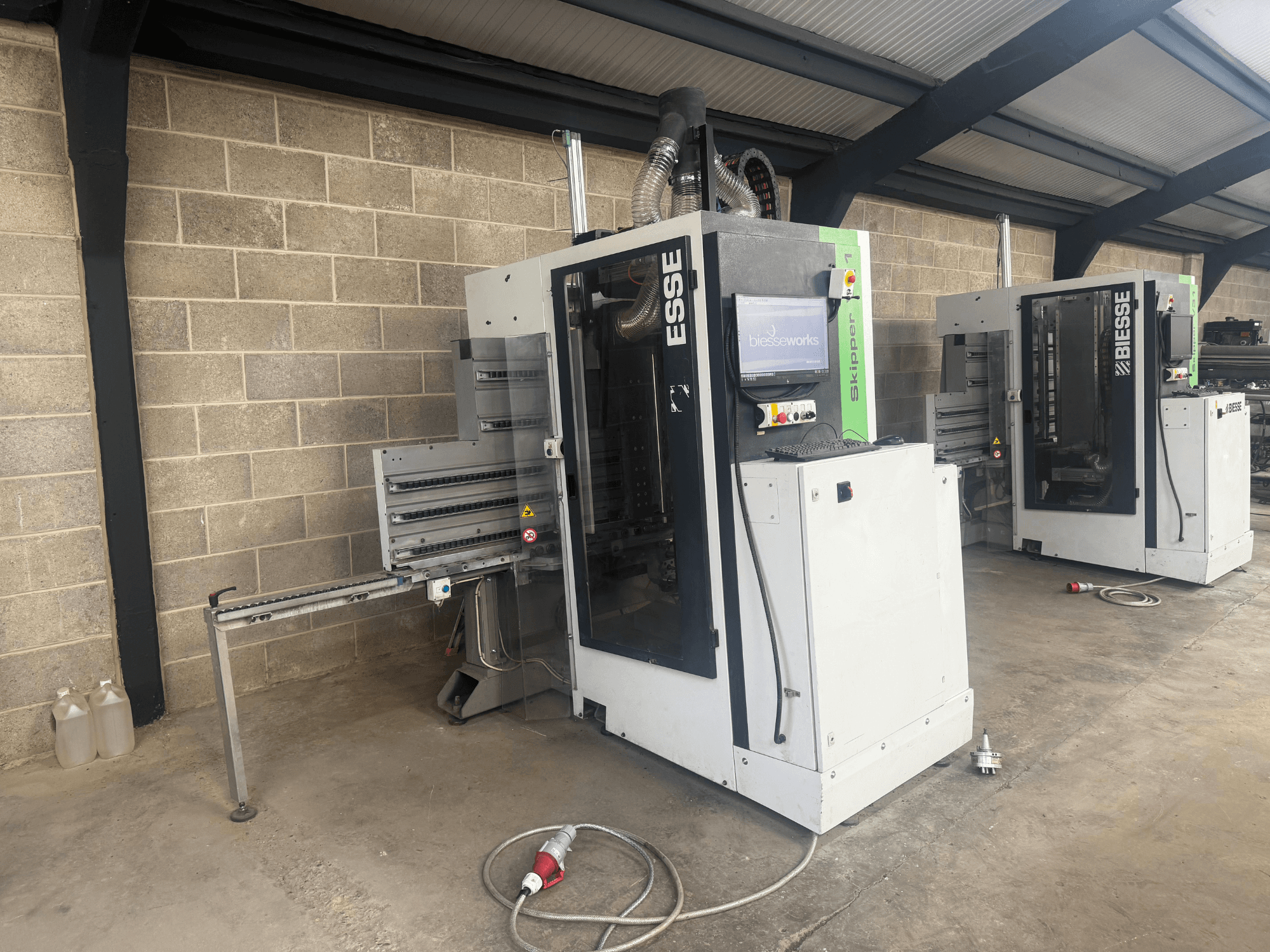 BIESSE Skipper v31 träborrmaskin i sidovy, med kontrollpanel och intilliggande maskiner, placerad i en verkstad.