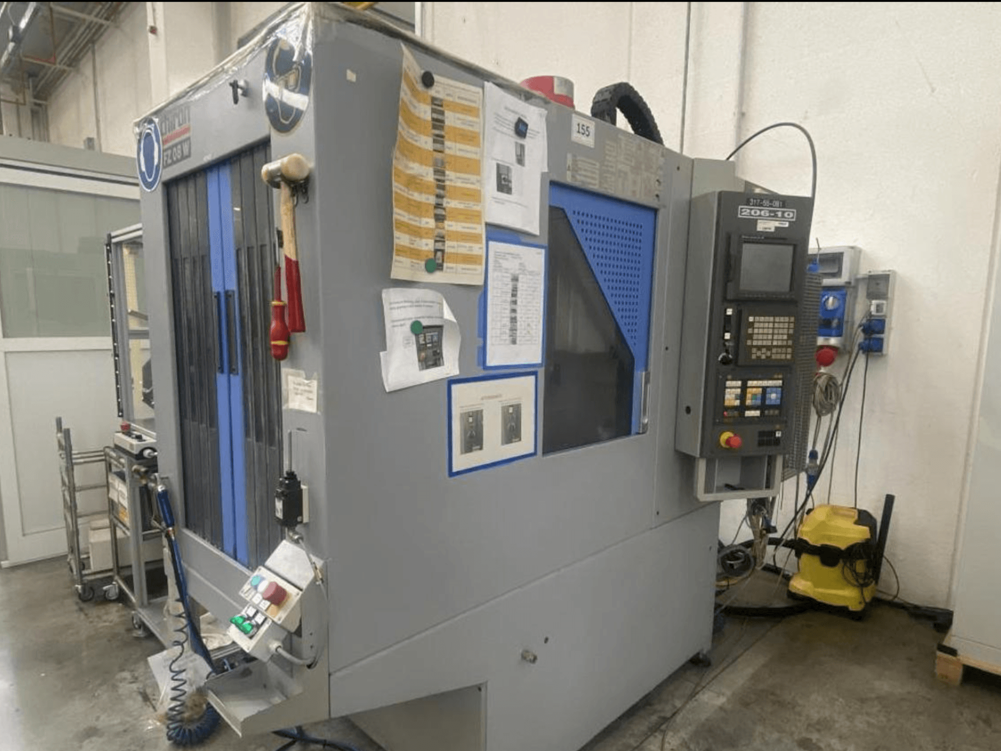 CNC-maskin av Shin Lin, framifrån, med kontrollpanel, manöverknappar och bifogade säkerhetsinstruktioner.