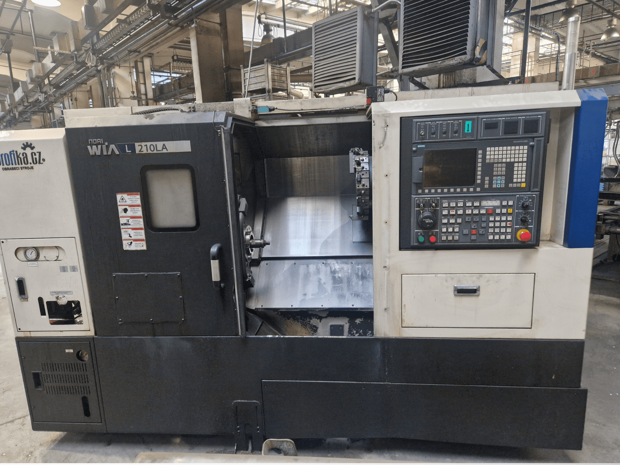 WIA L210LA CNC-svarv, framifrån, har kontrollpanel med knappar, display och ett synligt bearbetningsområde.