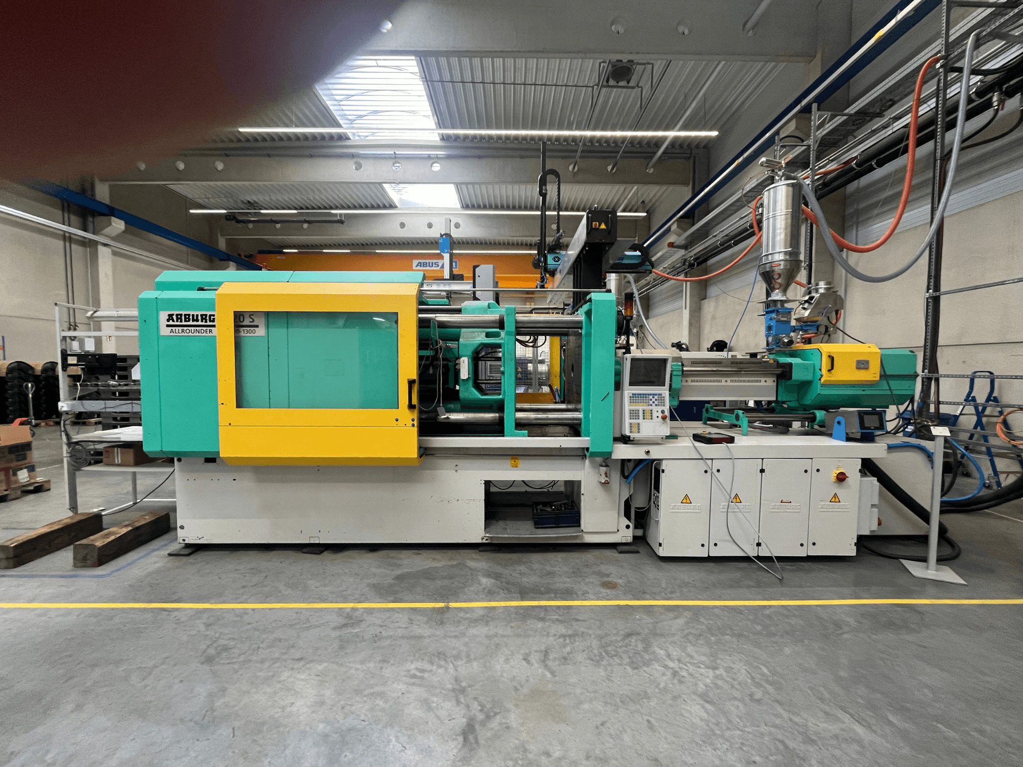 ARBURG Allrounder 370S plastformsprutningsmaskin, vy från sidan, med grönt och gult hölje, styrgränssnitt synligt.