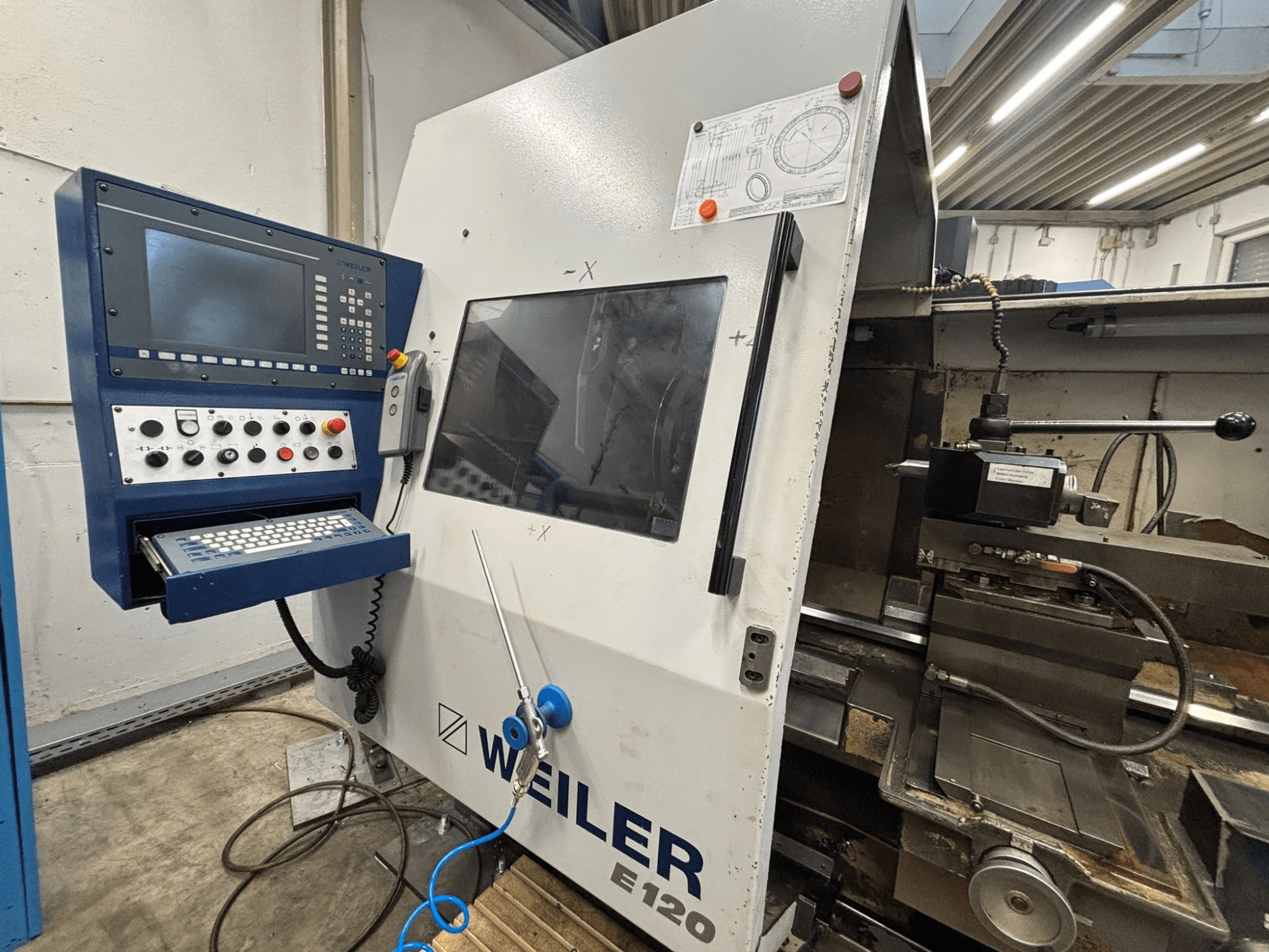 Weiler E-120 CNC-maskinens kontrollpanel och gränssnitt, framifrån med synliga knappar, displayskärm och manöverkomponenter.
