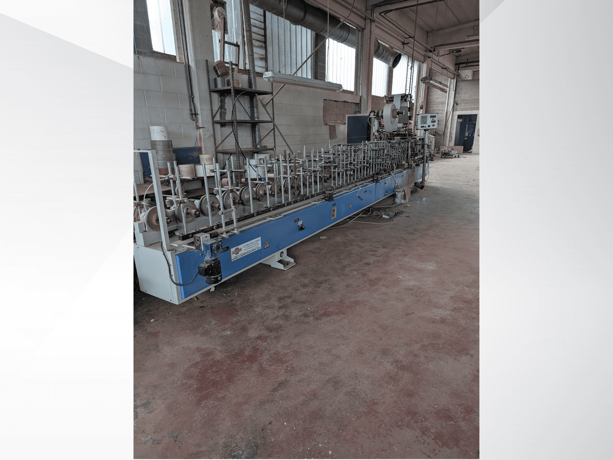 Frontvy av en PUR-33-L-maskin för trä, med flera spindlar och en elegant blå design i en industriell miljö.