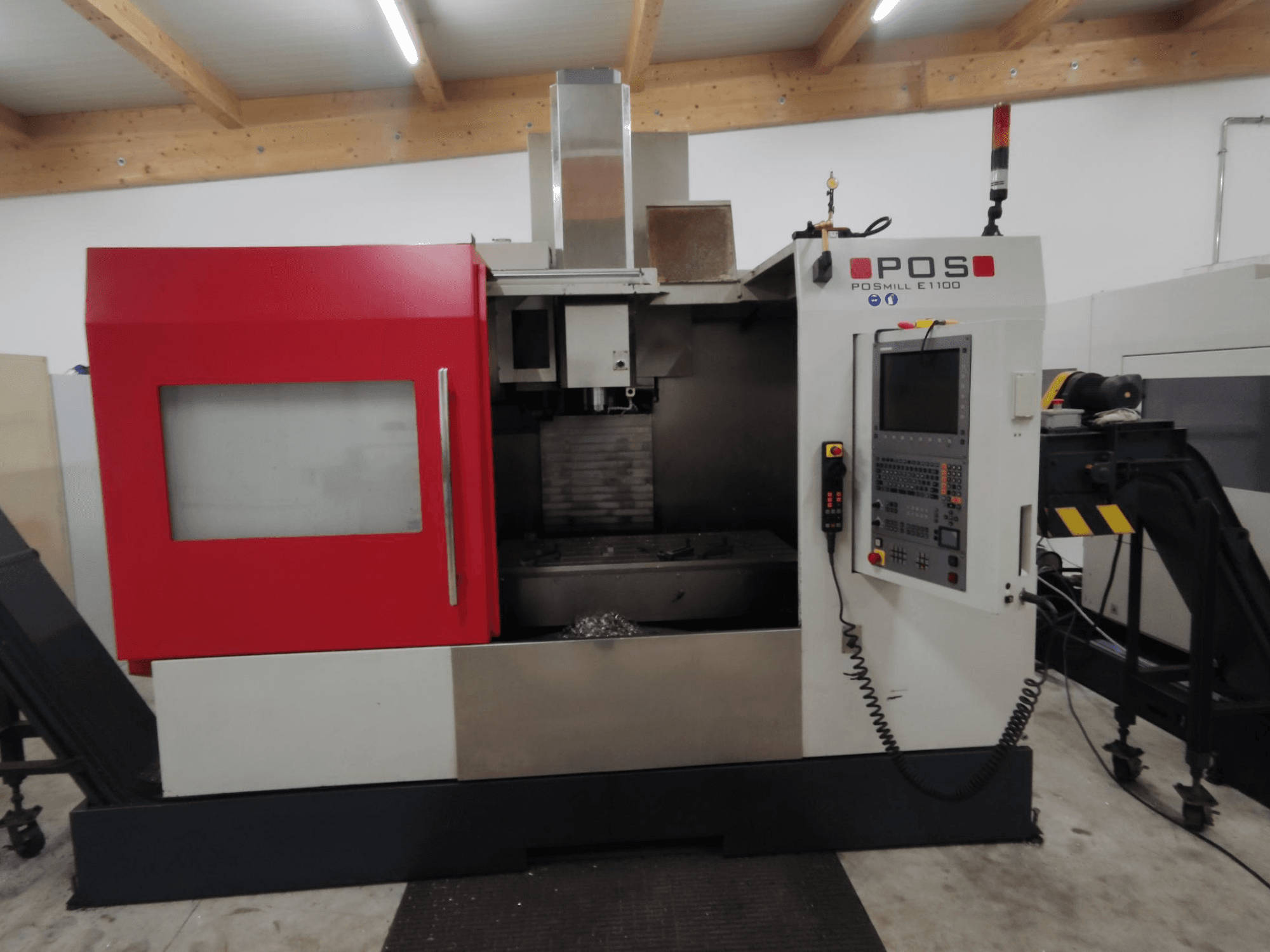POS POSMILL E1100 CNC-fräsmaskin framifrån med rött hölje, kontrollpanel och säkerhetslampa på ovansidan.