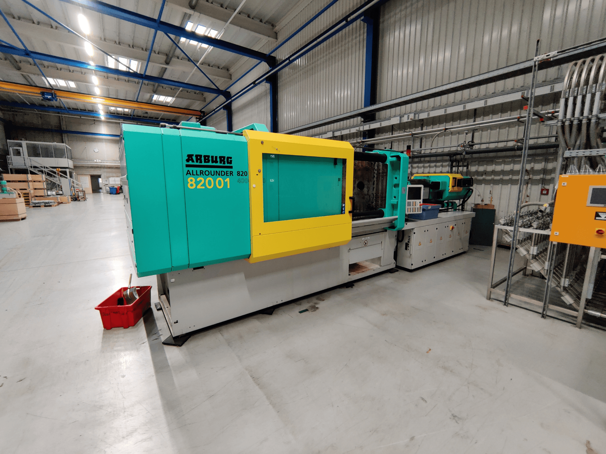 Frontvy av en Arburg 820 S 4000-2100 hydraulisk formsprutningsmaskin med ljusgröna och gula paneler.