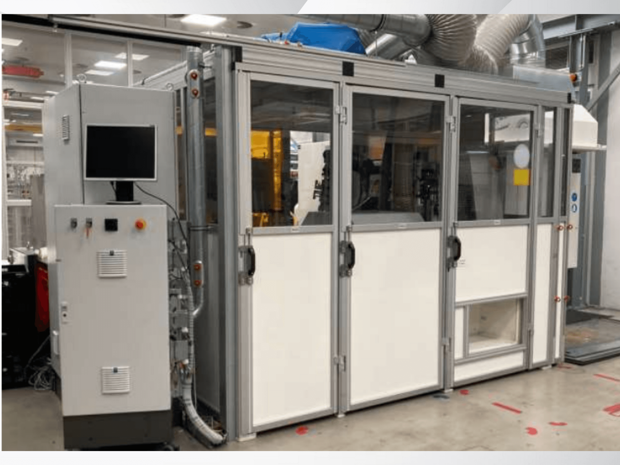 Industrimaskin med kontrollpanel, vy framifrån; har glasdörrar, ventilationskanaler och synliga ledningar.