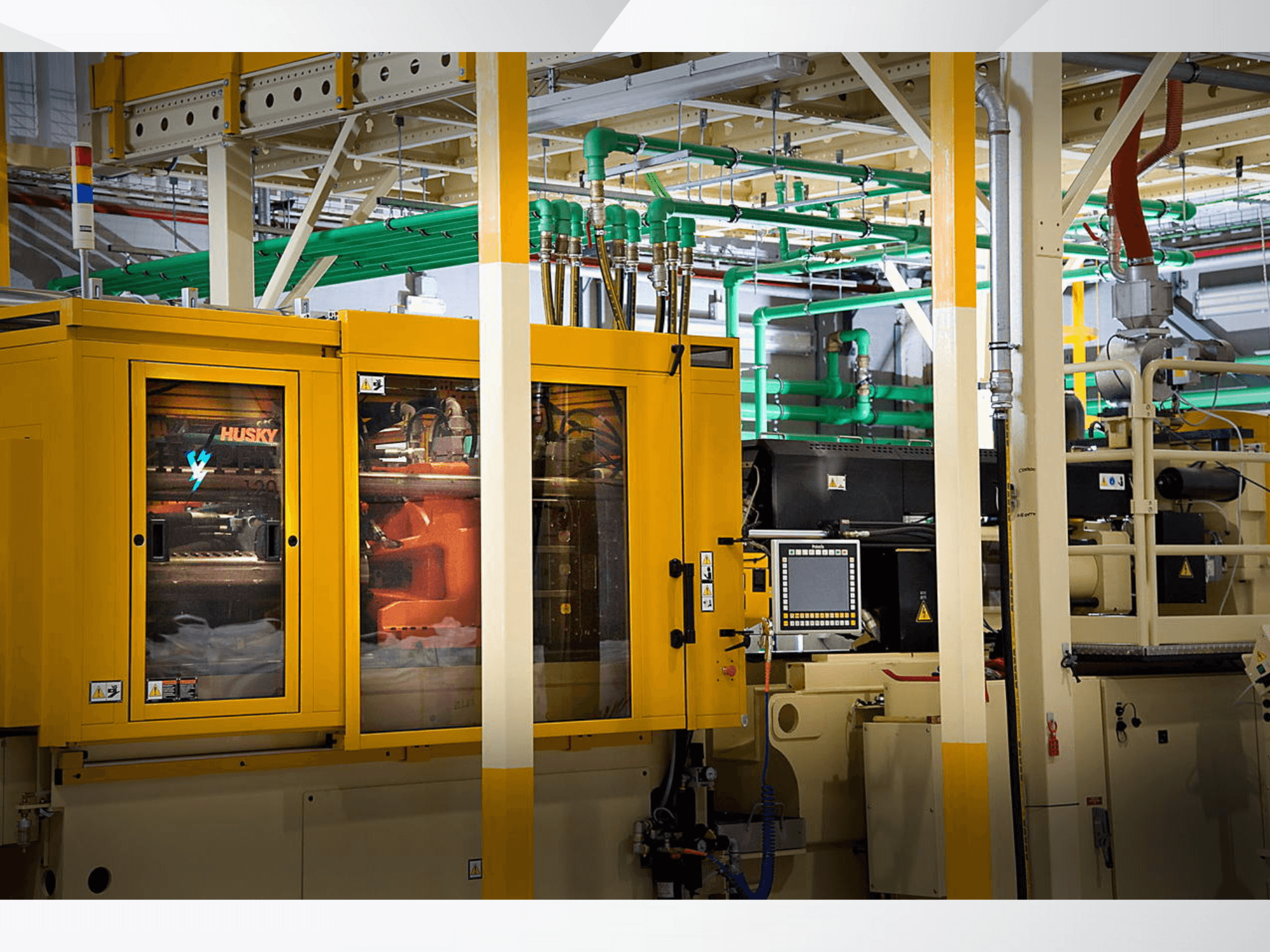 Husky industrimaskin i gult, vy framifrån med kontrollpanel och interna mekanismer mot en fabriksbakgrund.