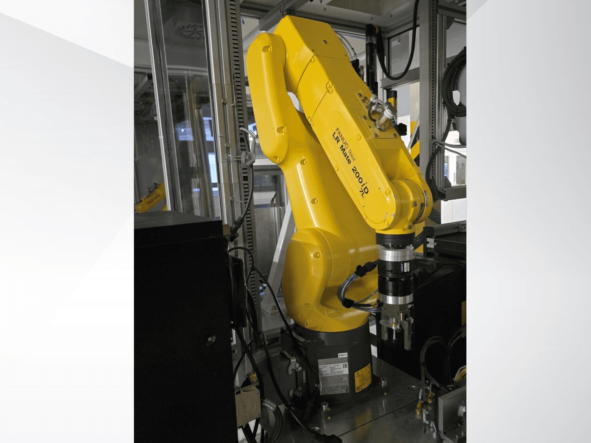 Gul Fanuc LR Mate 200iD robotarm från sidan, med ett gripdon och diverse kablar monterade.