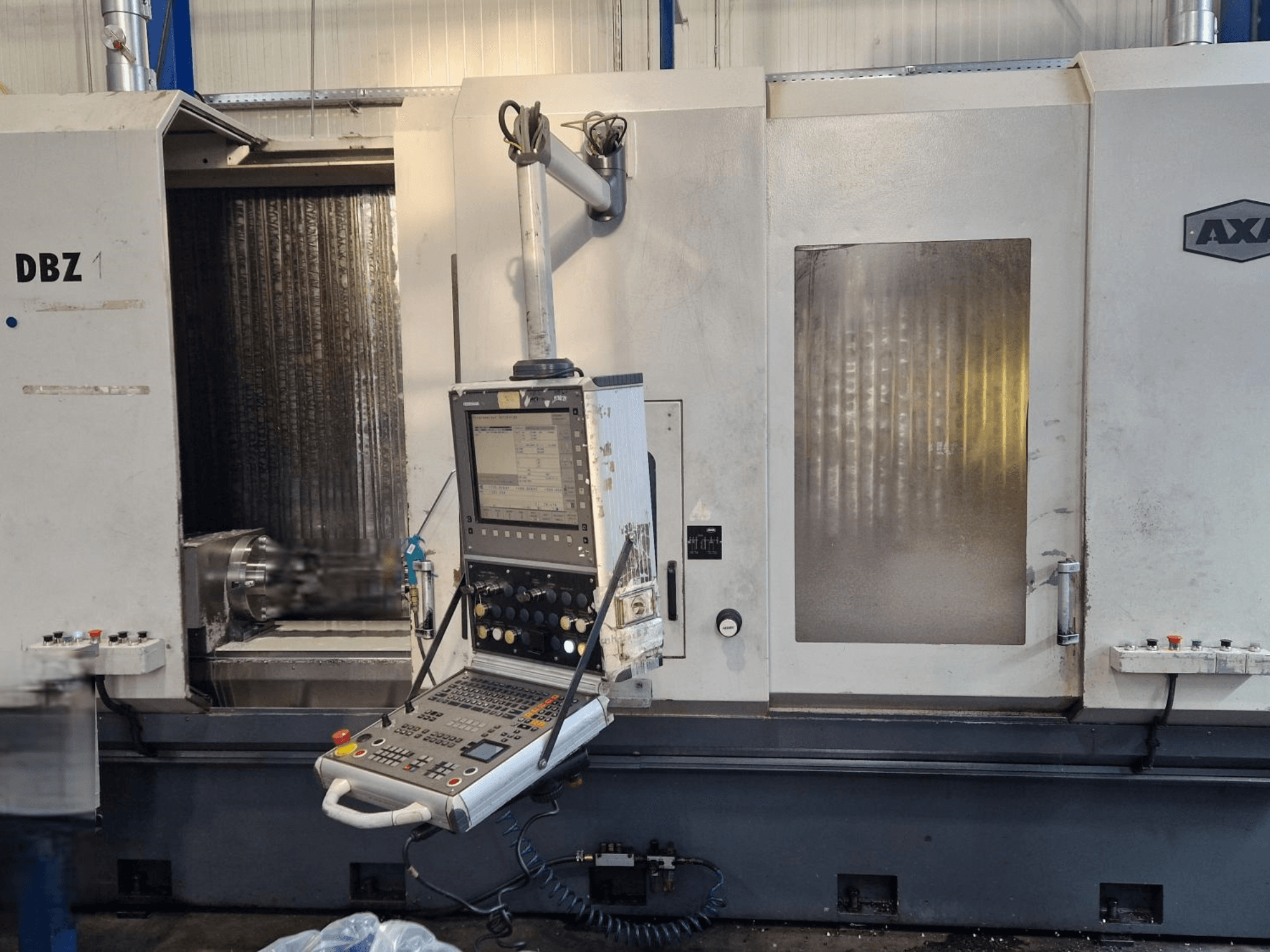AXA DBZ vertikalt bearbetningscenter sett från en vinklad frontvy, med kontrollpanel och synligt skärverktygsområde.