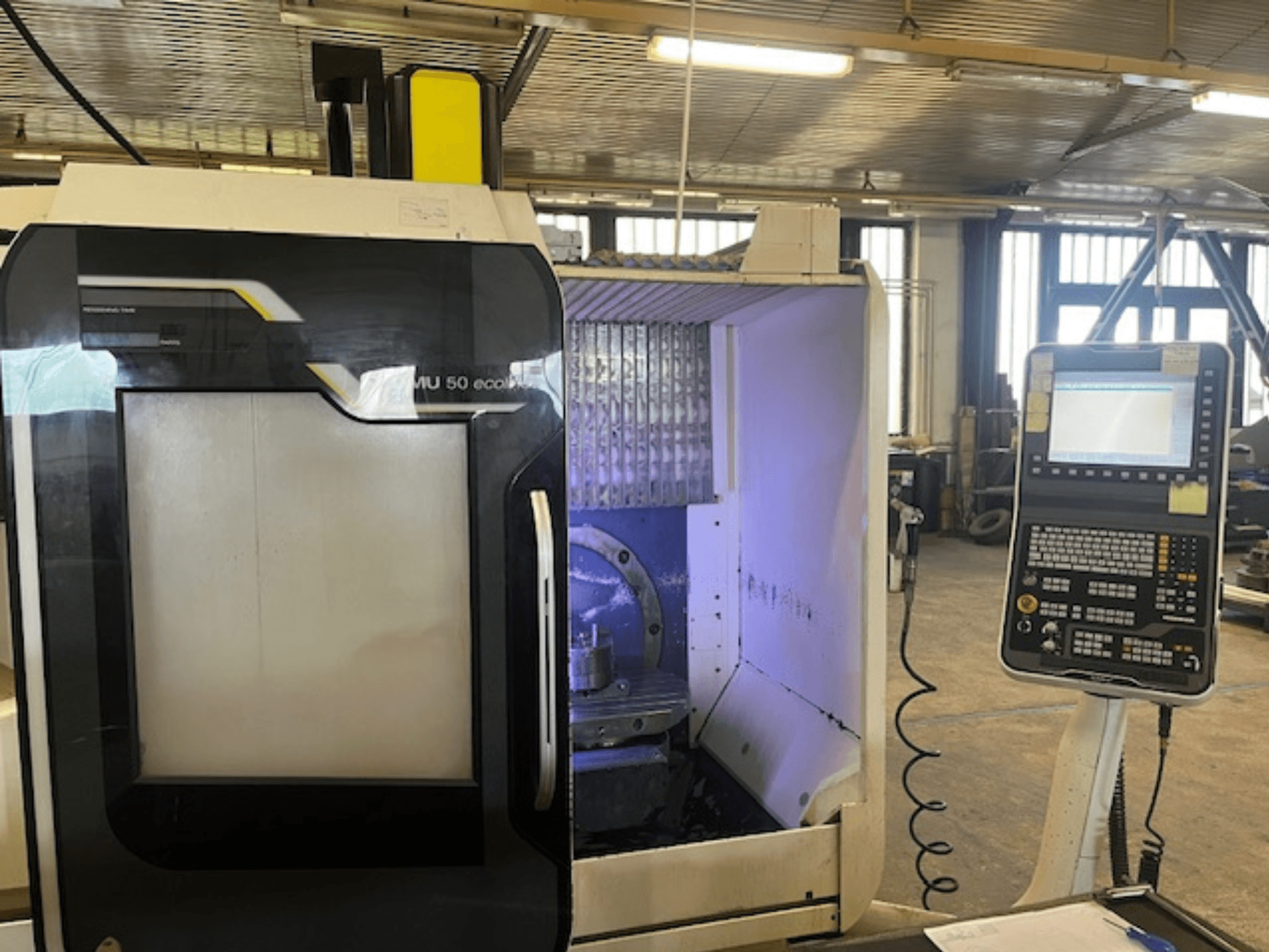 DMU 50 eco-fräsmaskin framifrån med kontrollpanel som visar verktygshållare och arbetsyta.