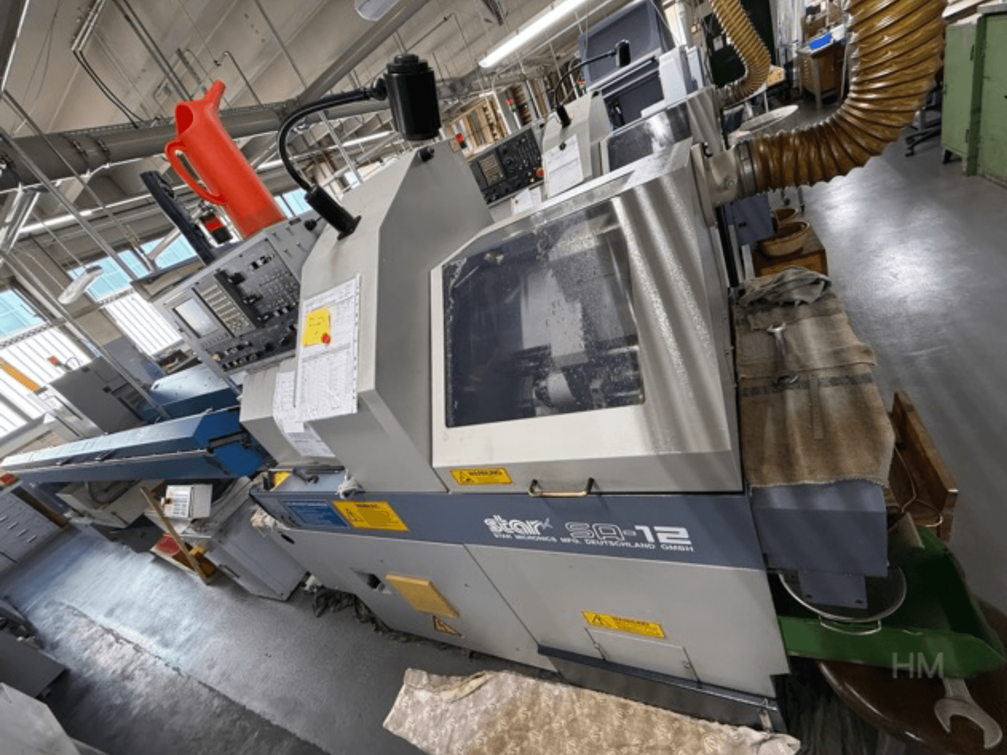 Star SQ-12 bearbetningscenter, sidovy med kontrollpanel, kylvätskebehållare och dammutsugningsslang synliga.