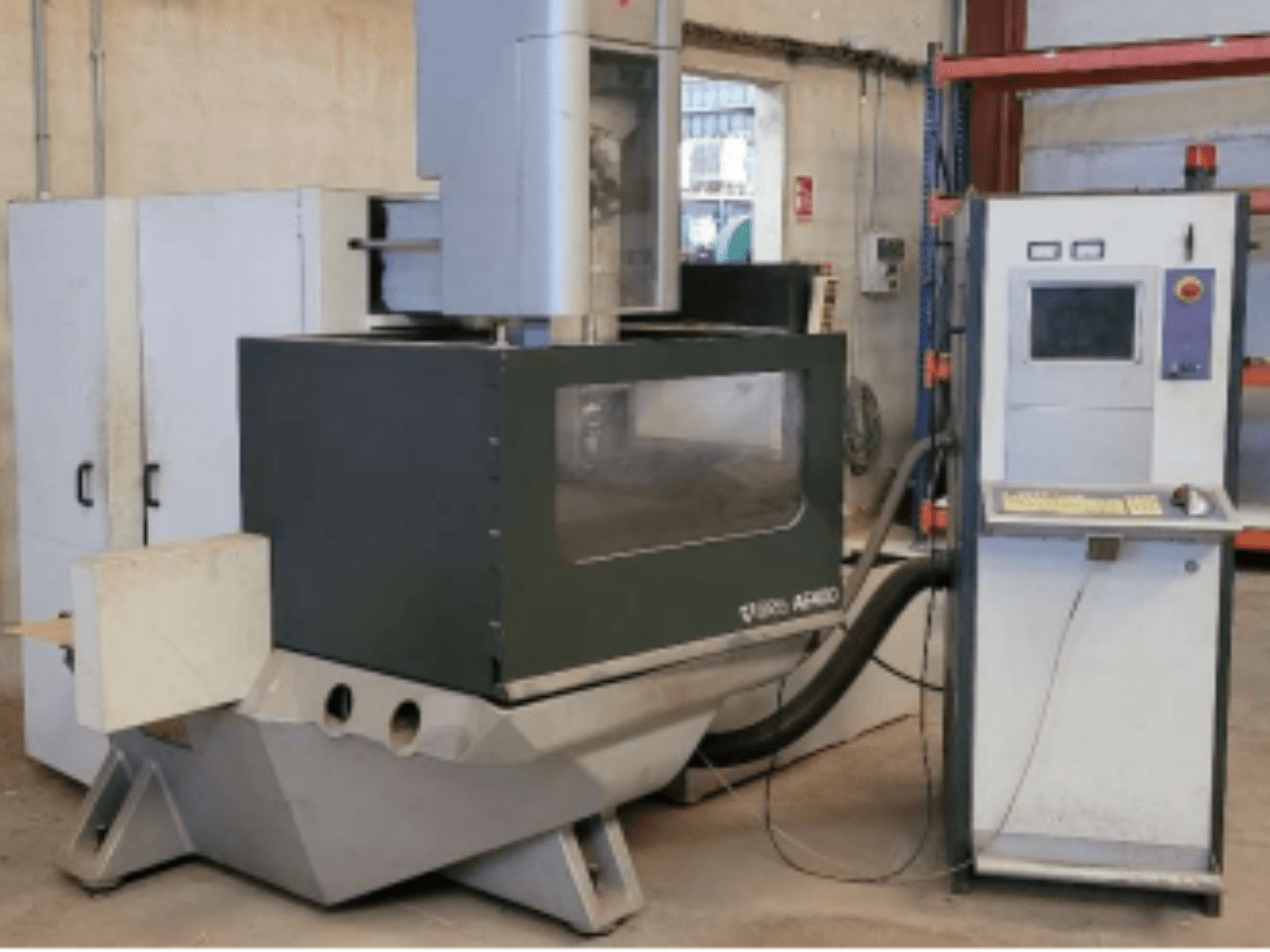 ONA AE 400 Wire EDM-maskin i verkstadsmiljö, med kontrollpanel till höger och stort skärområde.