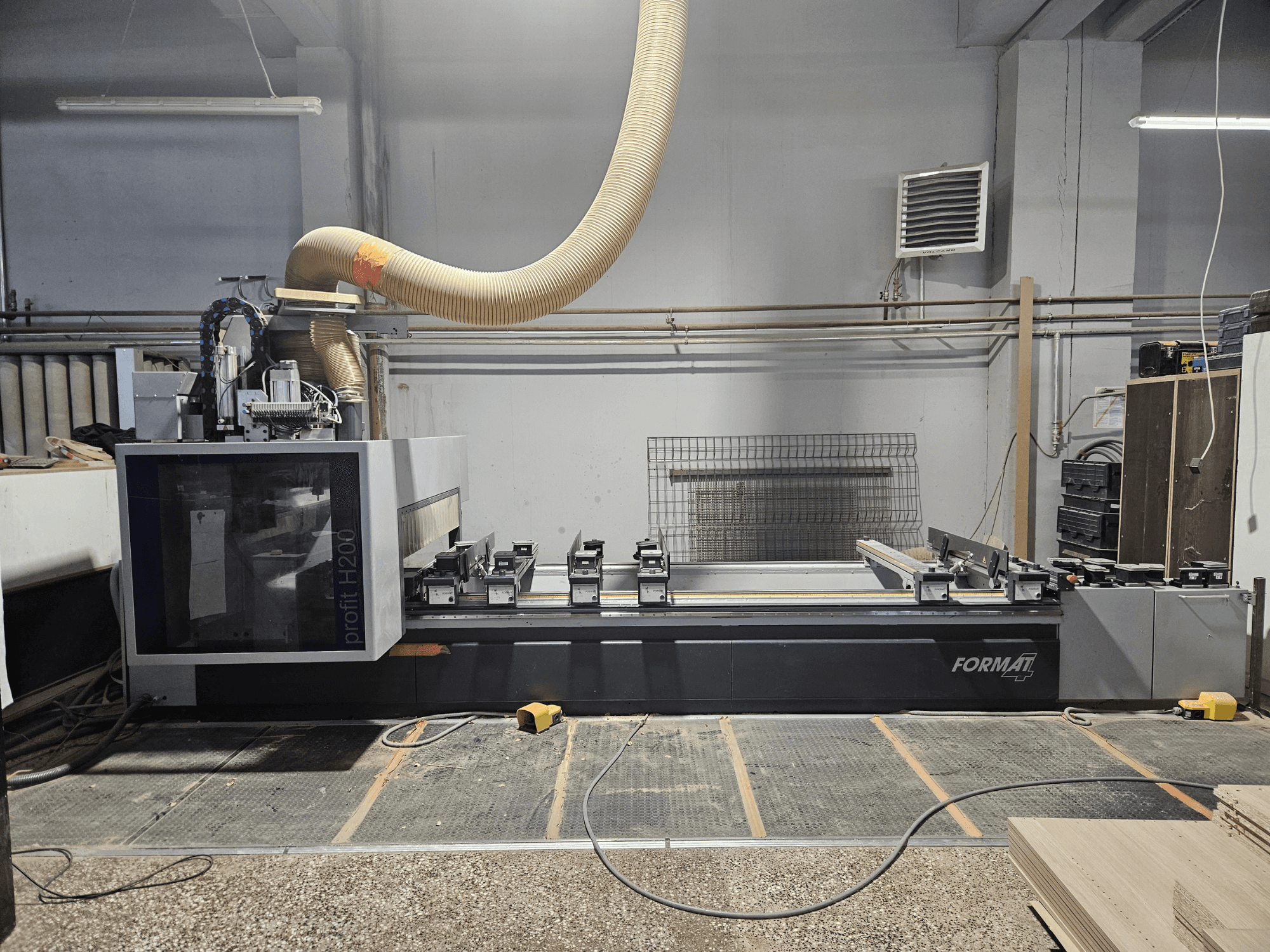 En CNC-maskin FORMAT profit H200 i en verkstad, sidovy, visar arbetsytan och dammutsugningssystemet.