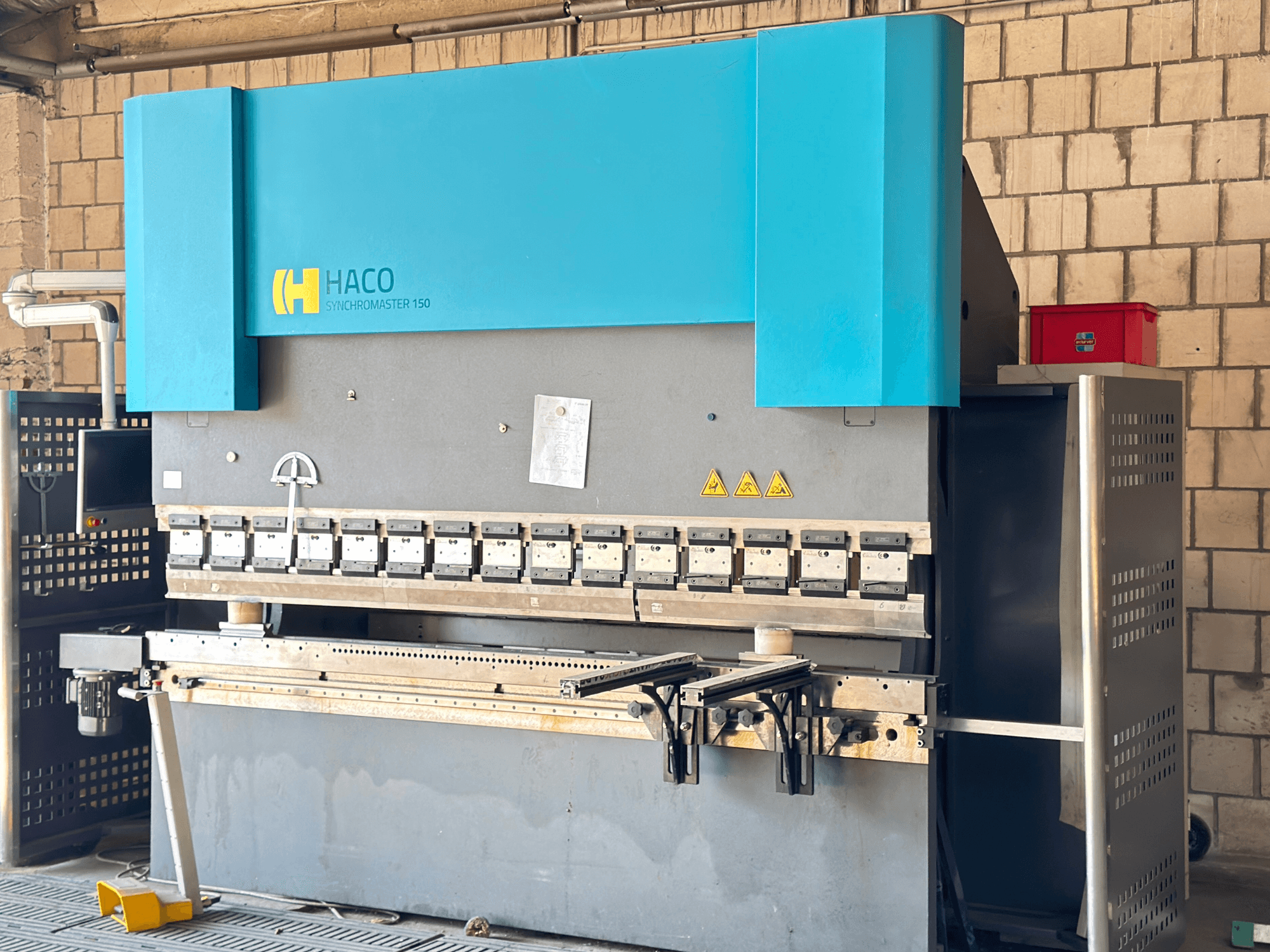 Kantpress HACO SRM30150, vy framifrån; inkluderar kontrollpanel och klämbackar, med synliga varningsetiketter.