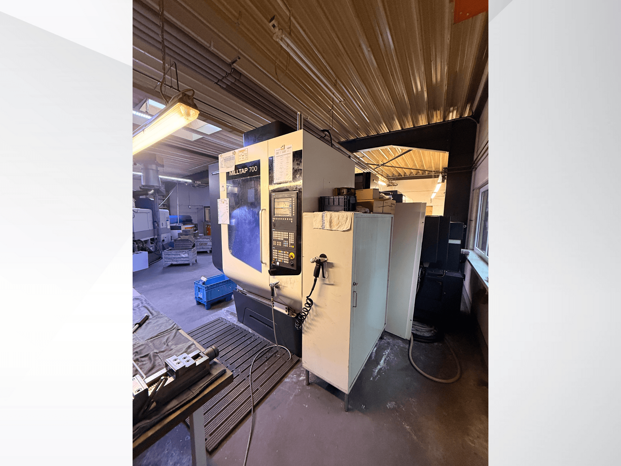 Milltap 700 CNC-maskin i verkstad; framifrån syns kontrollpanel, verktygshyllor och förvaringsutrymmen med belysning ovanför.