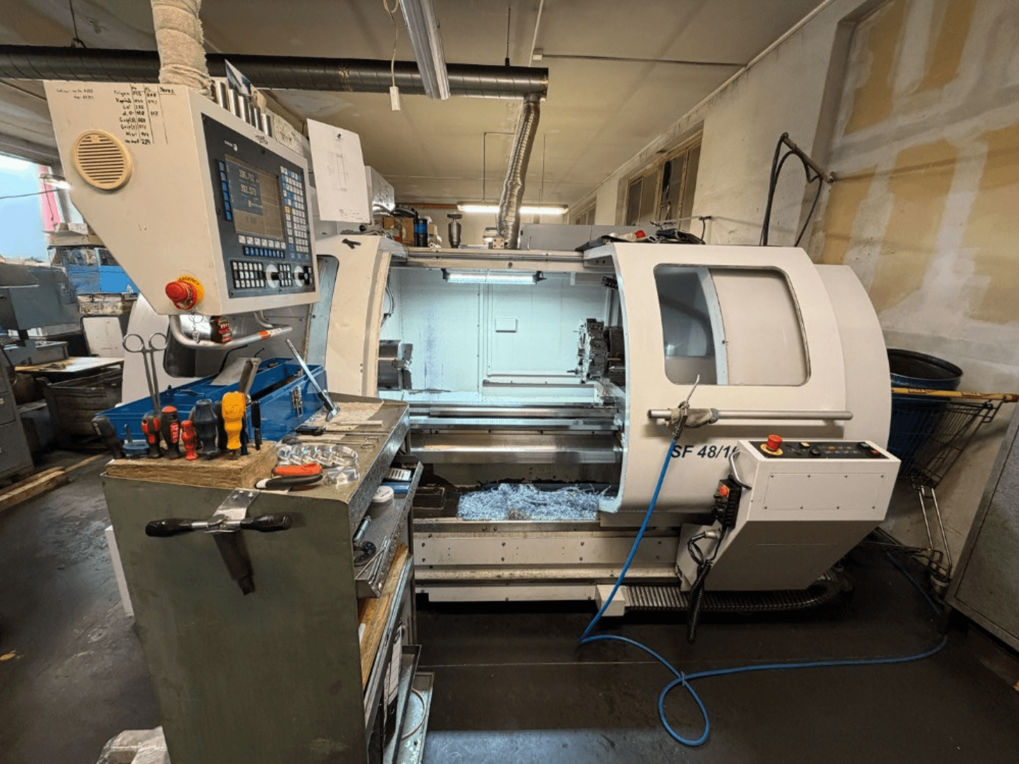 Horisontell svarv MICROCUT SF 48/1000 sedd framifrån, med kontrollpanel och verktyg på arbetsbänken.