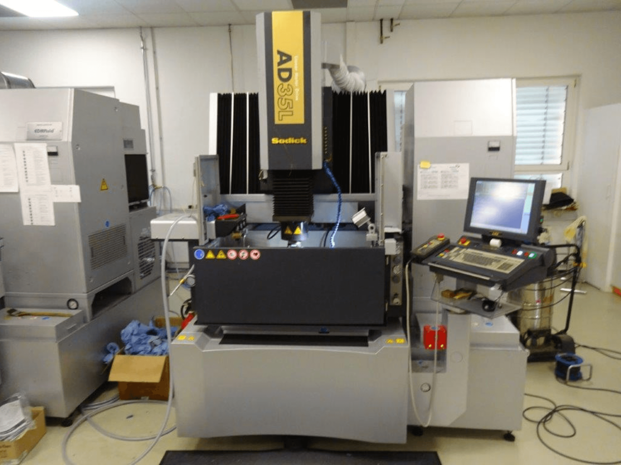 Sodick AD35L elektrisk utmatningsmaskin, framifrån med kontrollpanel, kylsystem och arbetsområde synliga.