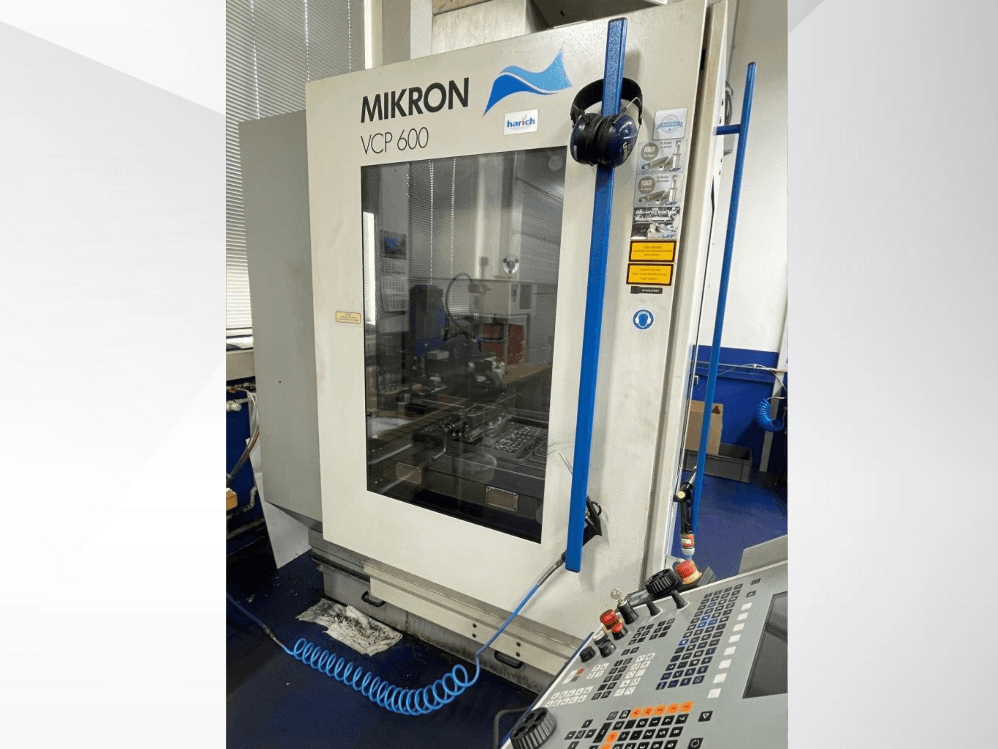 Mikron VCP 600 CNC-maskin, vy framifrån, med kontrollpanel med knappar och synligt bearbetningsområde bakom glas.