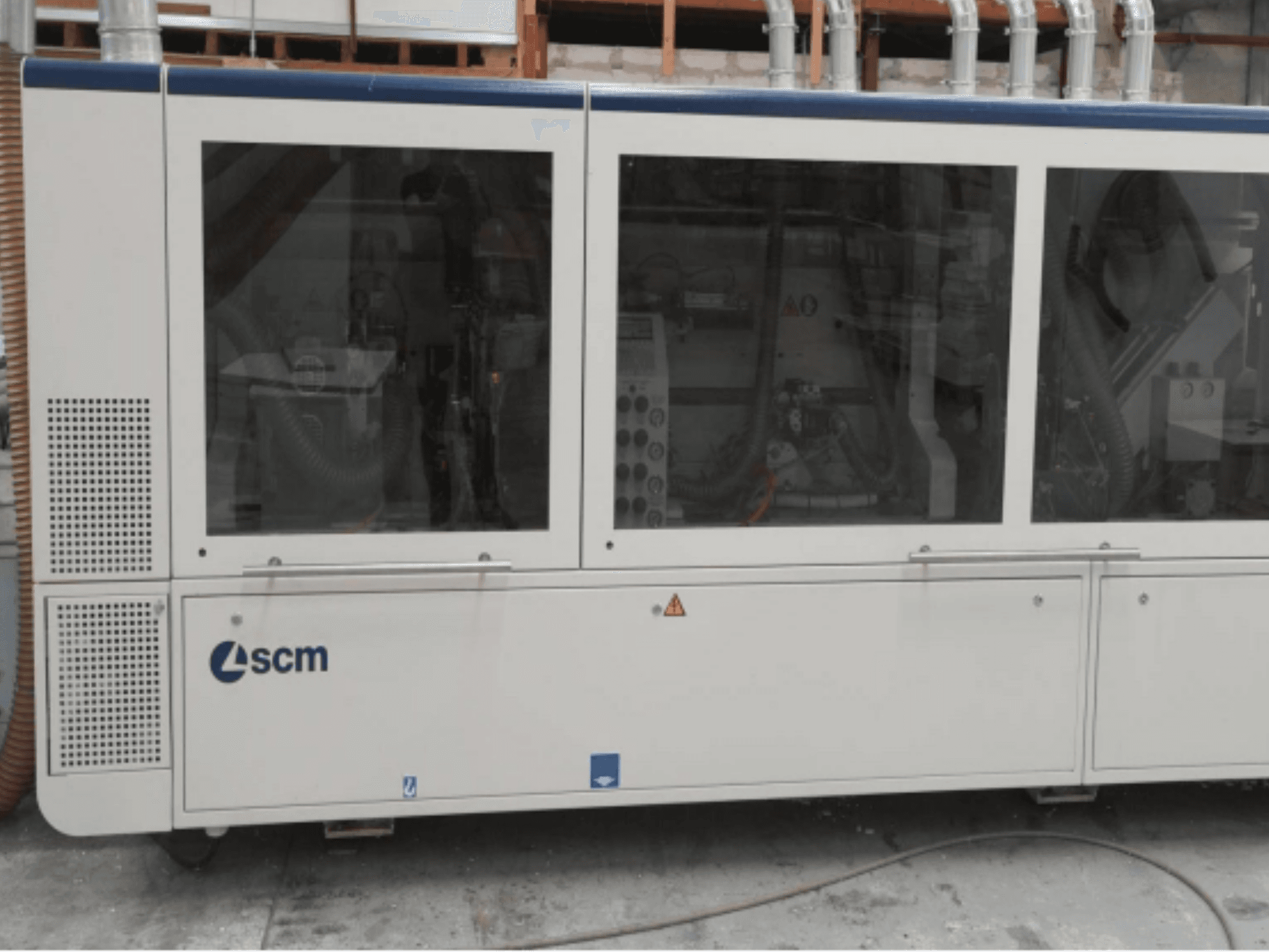 SCM industrimaskin, sidovy, har transparenta paneler och synliga ventilationsöppningar; utformad för effektivitet i tillverkningsprocesser.