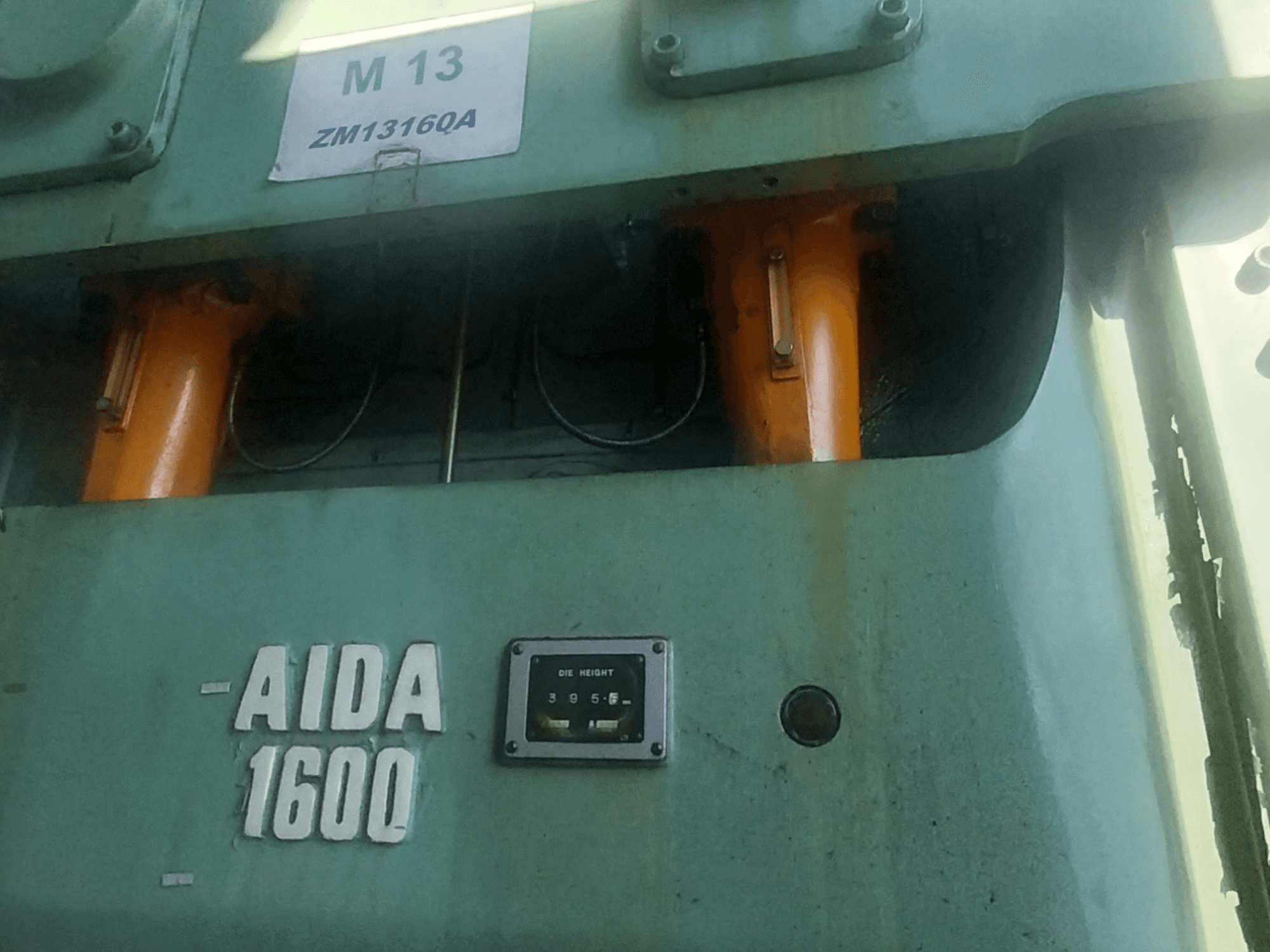 AIDA NC2-1600 mekanisk stanspress, framifrån; orange hydraulkomponenter och verktygshöjdmätare synliga.