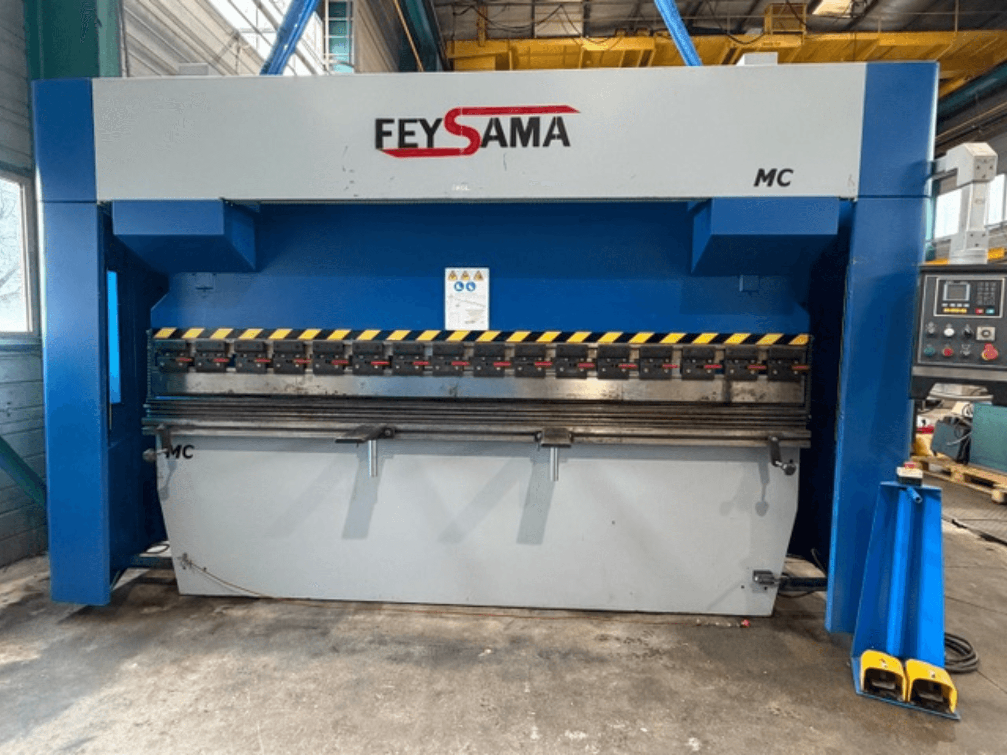 Frontvy av FEYSAMA MCCH 6/3050 kantpress, med gula säkerhetsmarkeringar, kontrollpanel till höger och robust bas.