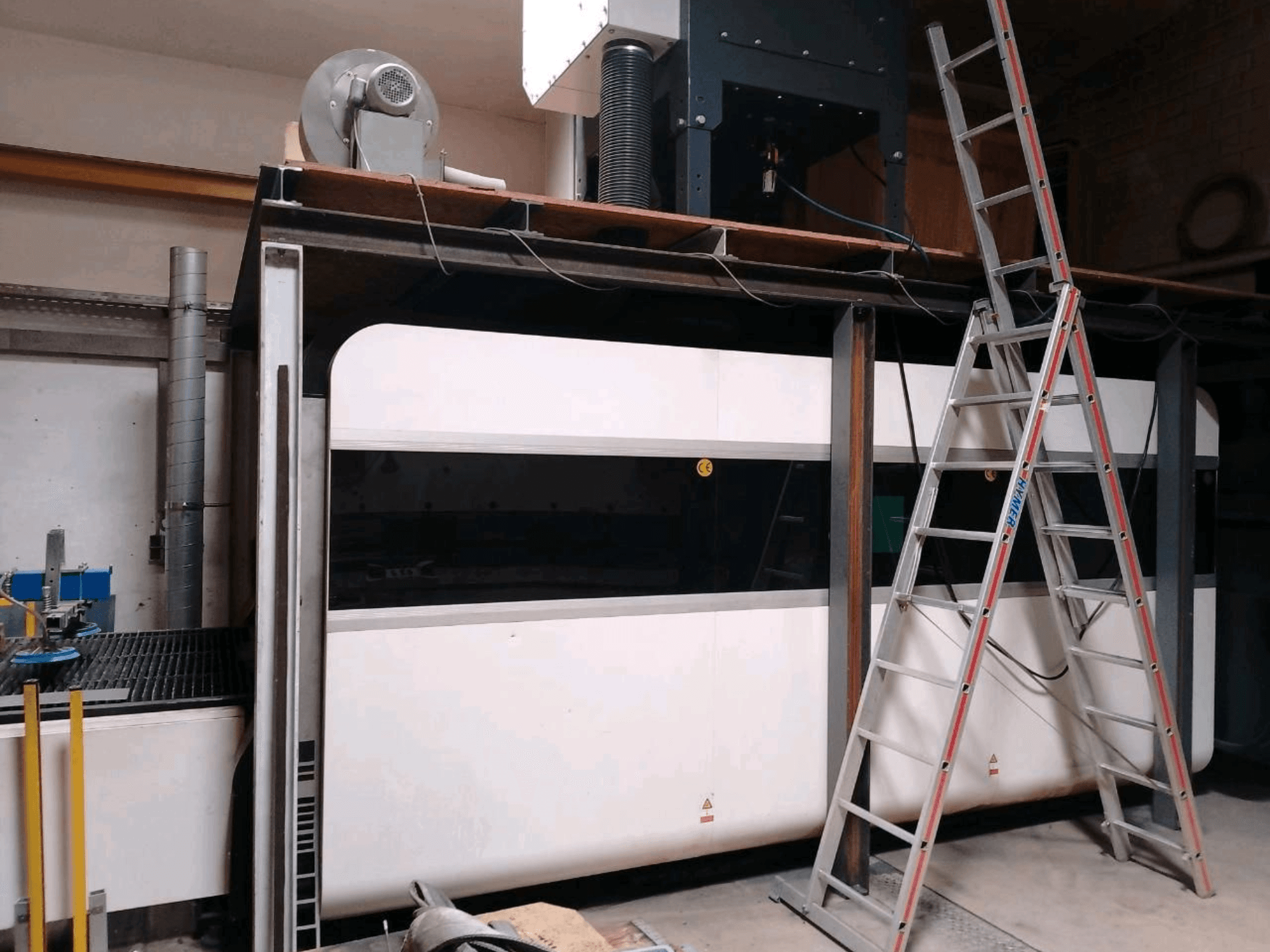 En GWEIKE LF3015GA-fiberlaserskärmaskin i en verkstad, visad framifrån med metallram och åtkomststege.