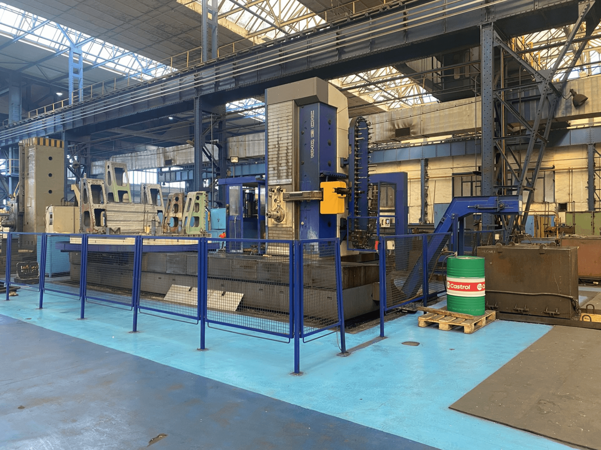 TOS WHQ 13 CNC-borrmaskin i en verkstad, vy framifrån, med blå ram och omgivande säkerhetsstaket.