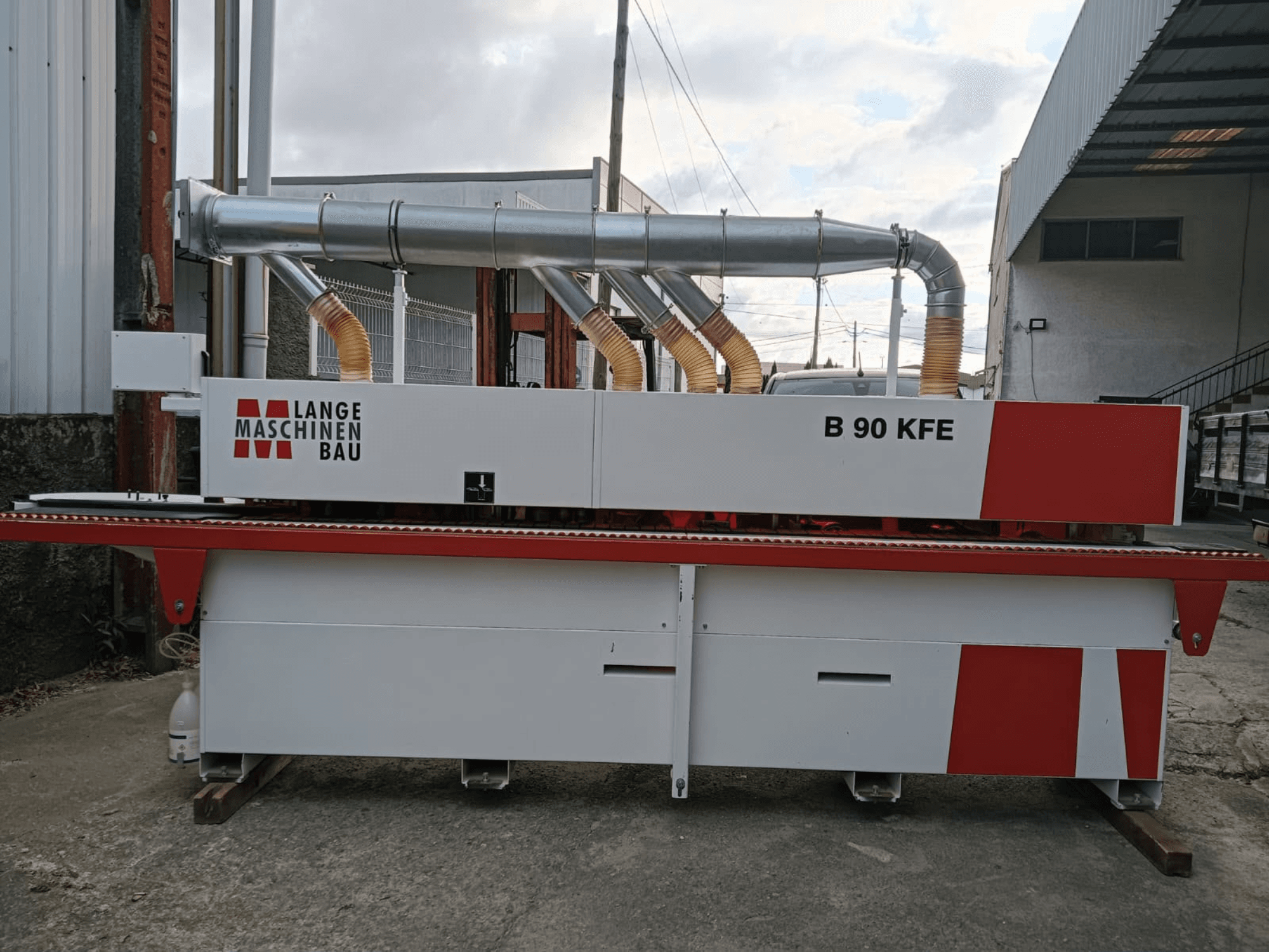 LANGE Maschinenbau B 90 KFE kantlistmaskin i sidovy med dubbla avgasrör och röda detaljer, placerad i en industriell arbetsmiljö.