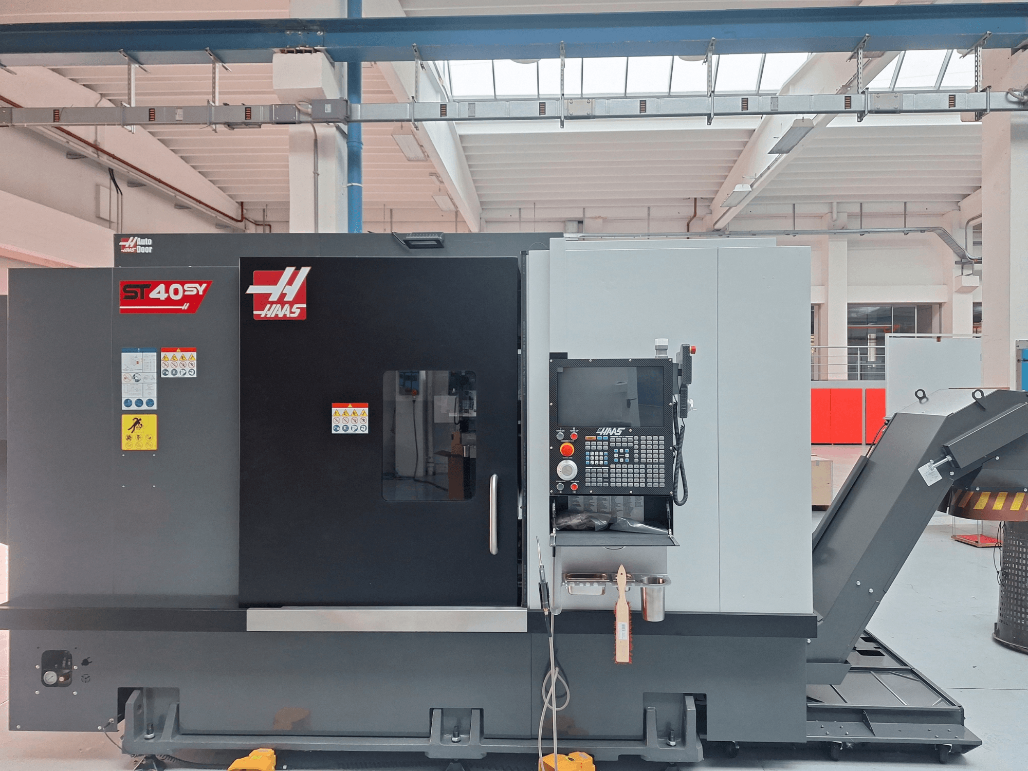 Haas ST-40SY horisontell svarv sedd från sidan, med kontrollpanel och säkerhetsetiketter.