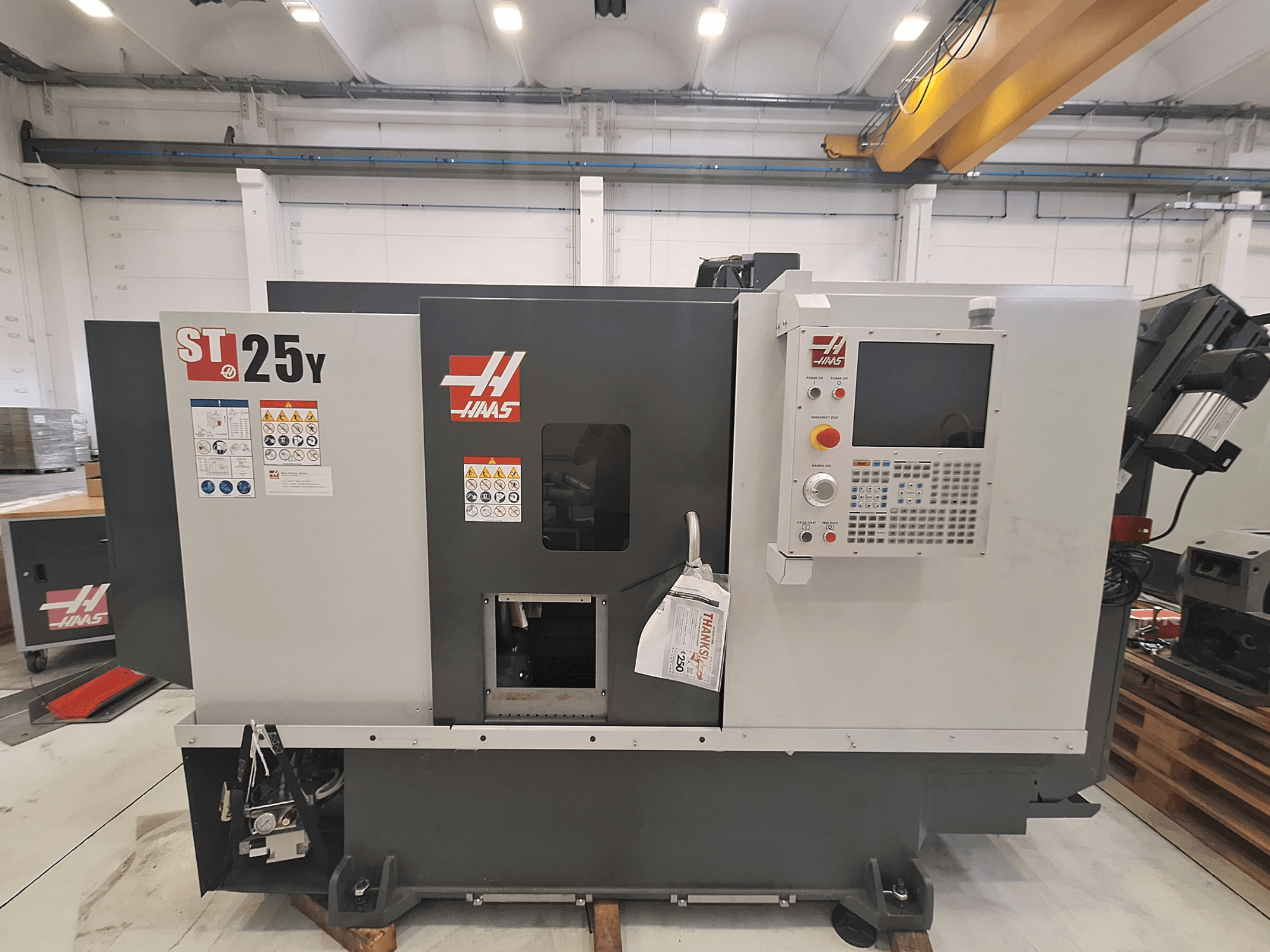 Haas ST-25Y horisontell svarv, framifrån, med kontrollpanel och säkerhetsetiketter. Perfekt för precisionsbearbetning.