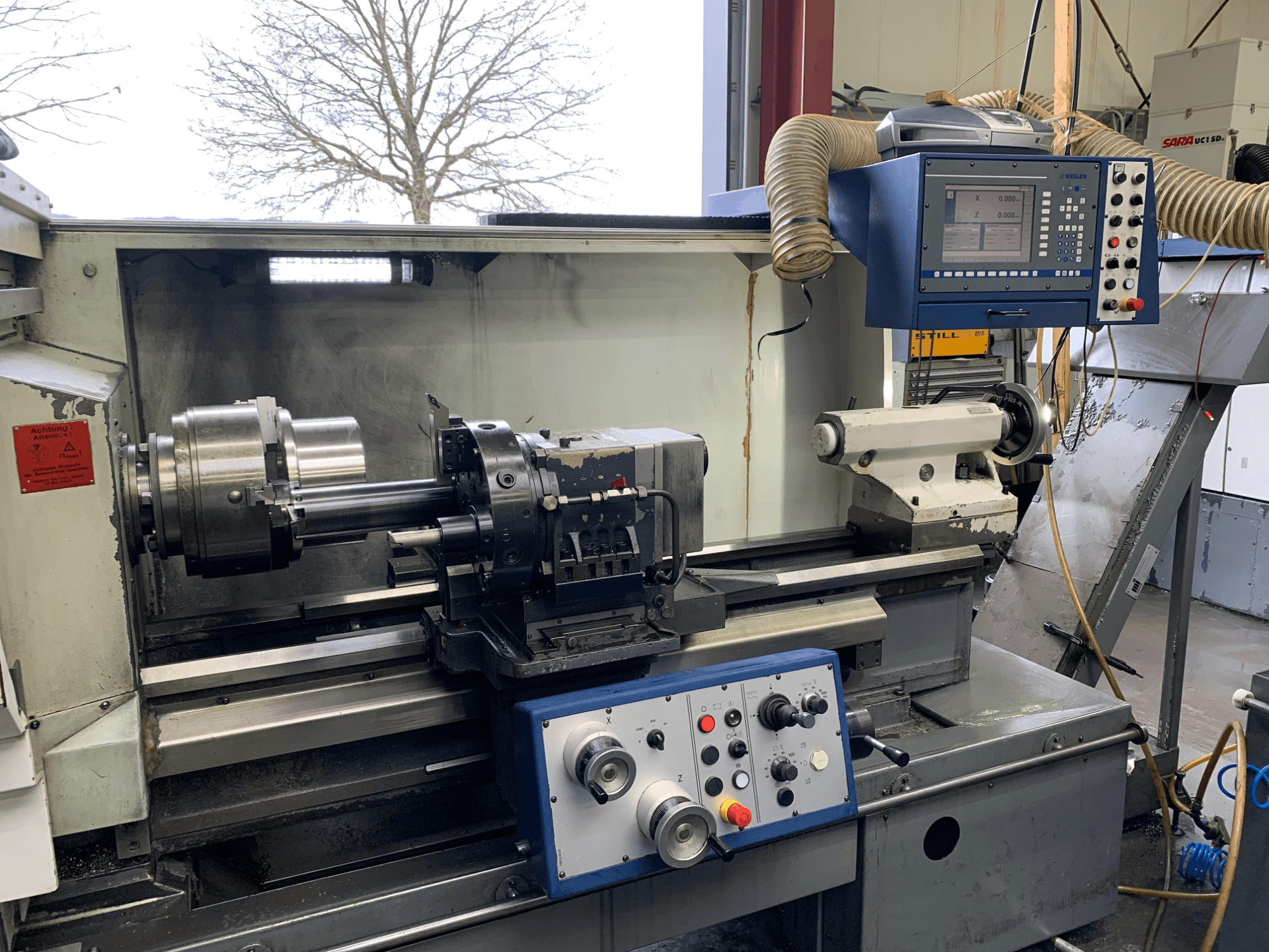 Weiler E55X1000 horisontell svarv i en verkstad, med kontrollpanel, svarv och verktygshållare. Vy framifrån.