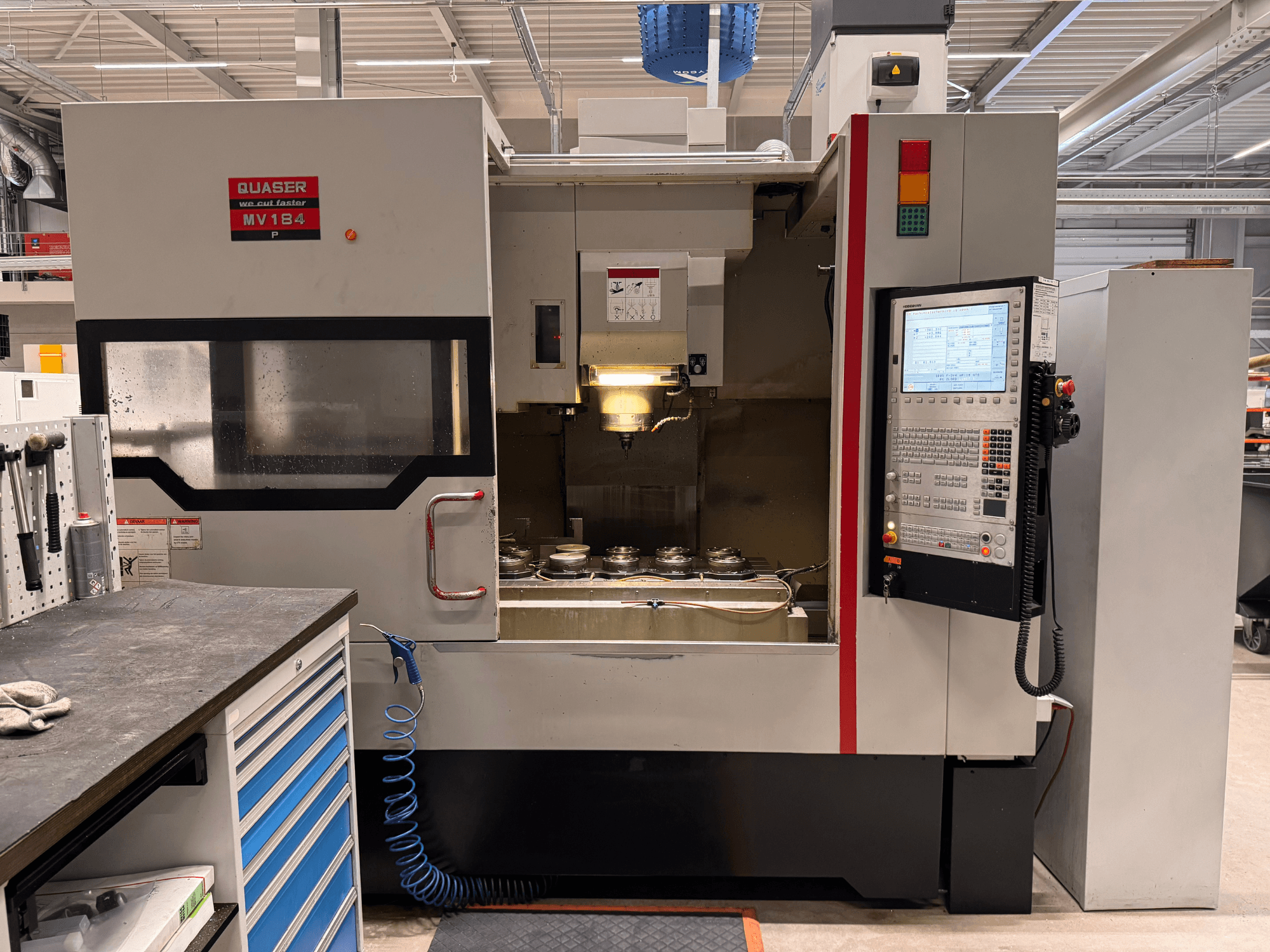 Vertikalt bearbetningscenter Quaser MV184P, framifrån, med kontrollpanel och verktygsförvaringsutrymme.