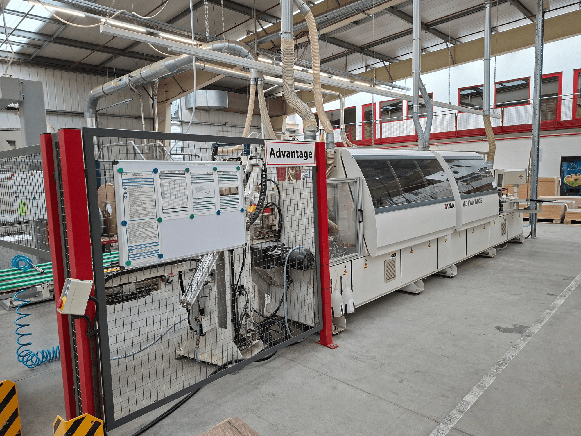 IMA Advantage 600 kantlistmaskin sedd framifrån med säkerhetsstaket och kontrollpanel i en verkstadsmiljö.