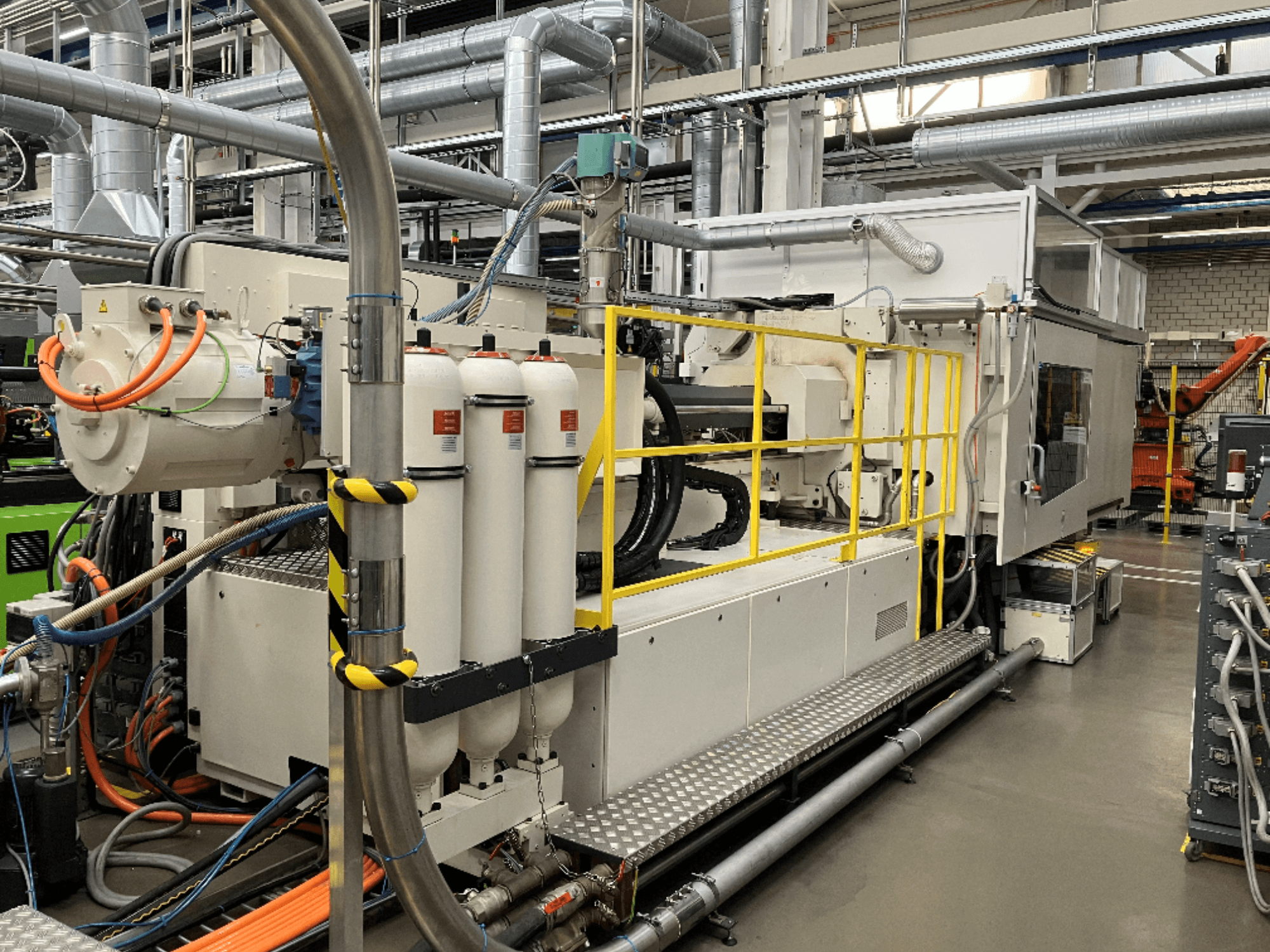 Industrimaskin med vitt och grått hölje, flera slangar och filtertankar; sidovy som visar driftsuppställning.