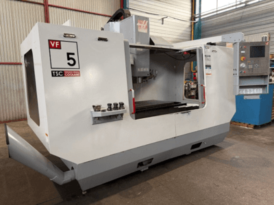 HAAS VF5-HE vertikalt bearbetningscenter, framifrån, med TSC-kylsystemet och manöverpanelen.