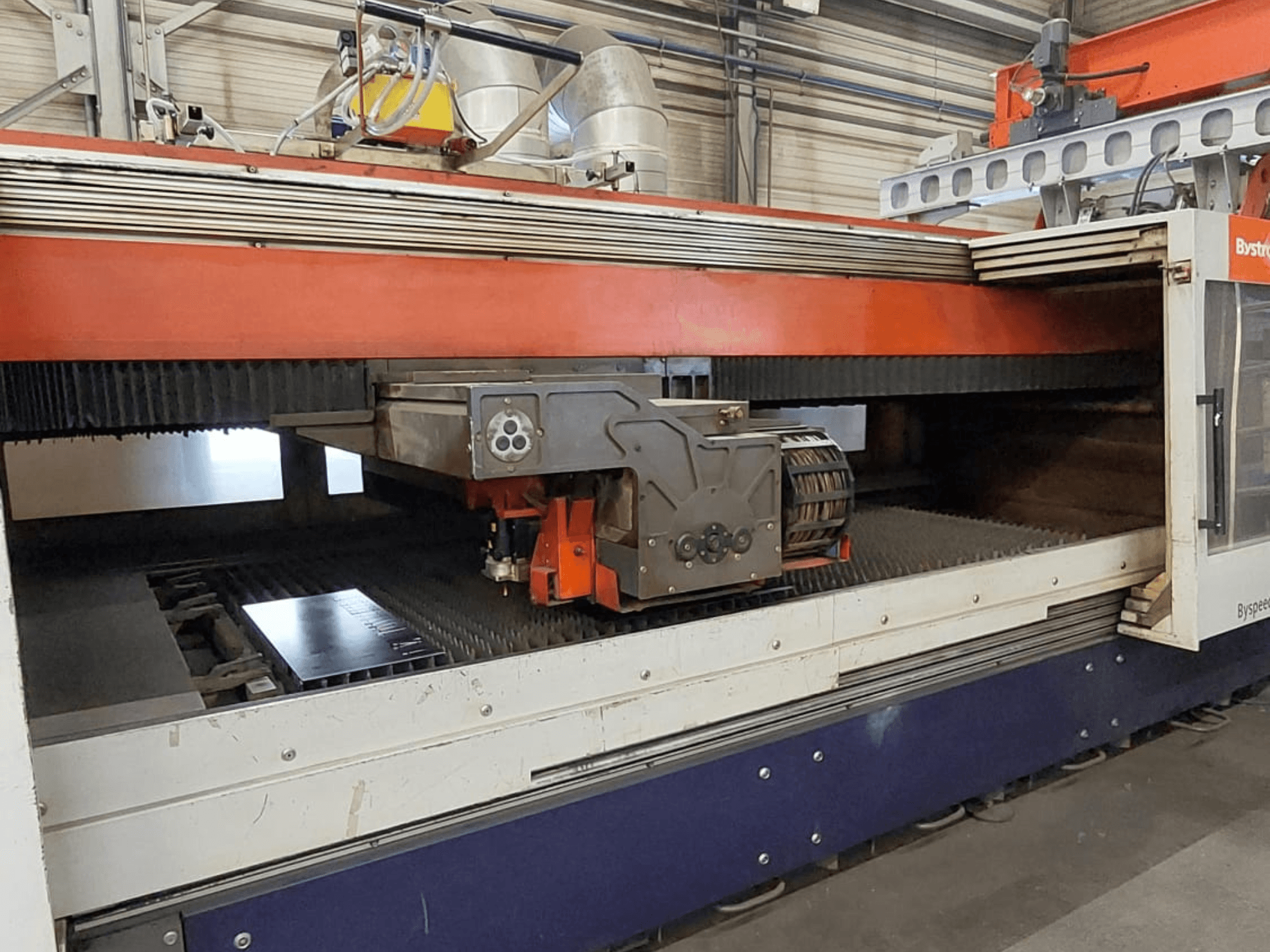 Bystronic BySpeed 3015 CO₂-laserskärmaskin, framifrån sett med skärhuvudet och plåten på skärbordet.
