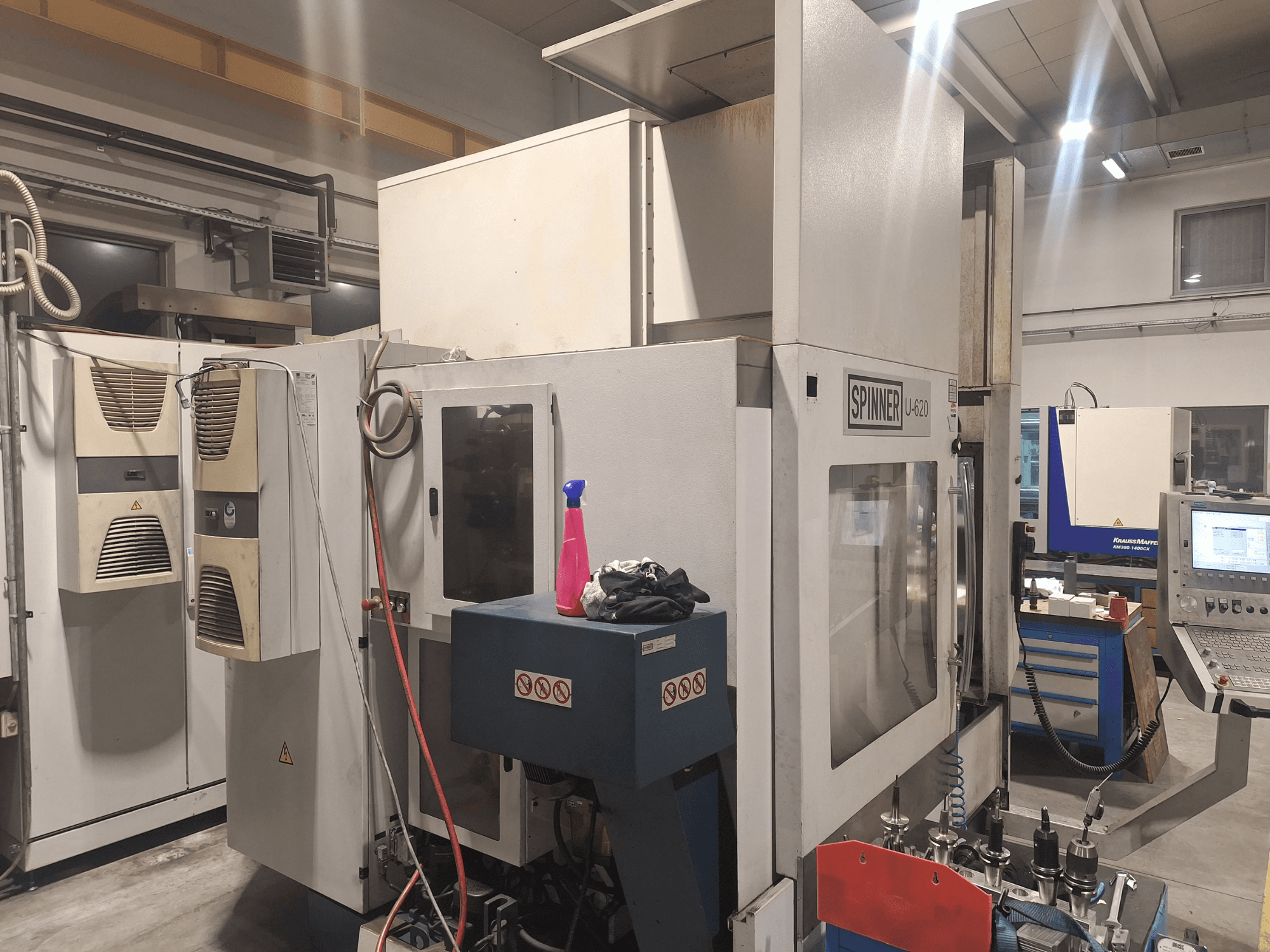 CNC-maskinen Spinner U-620 framifrån i en verkstad, med kontrollpanel och olika verktyg på en arbetsbänk i närheten.