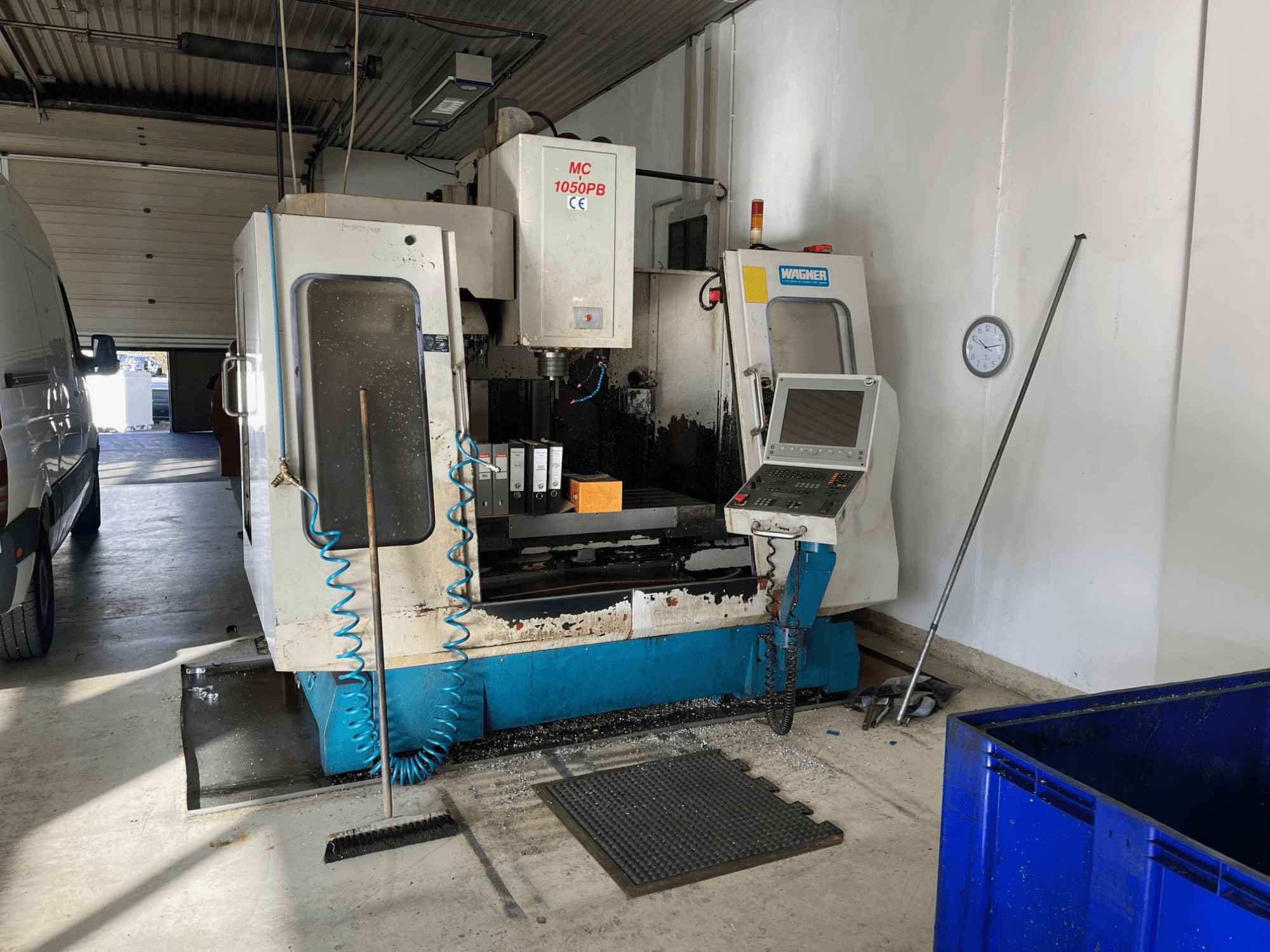 WAGNER MC 1050PB CNC-maskin i verkstad, framifrån, med kontrollpanel och arbetsområde; blå luftslang och rengöringsverktyg synliga.