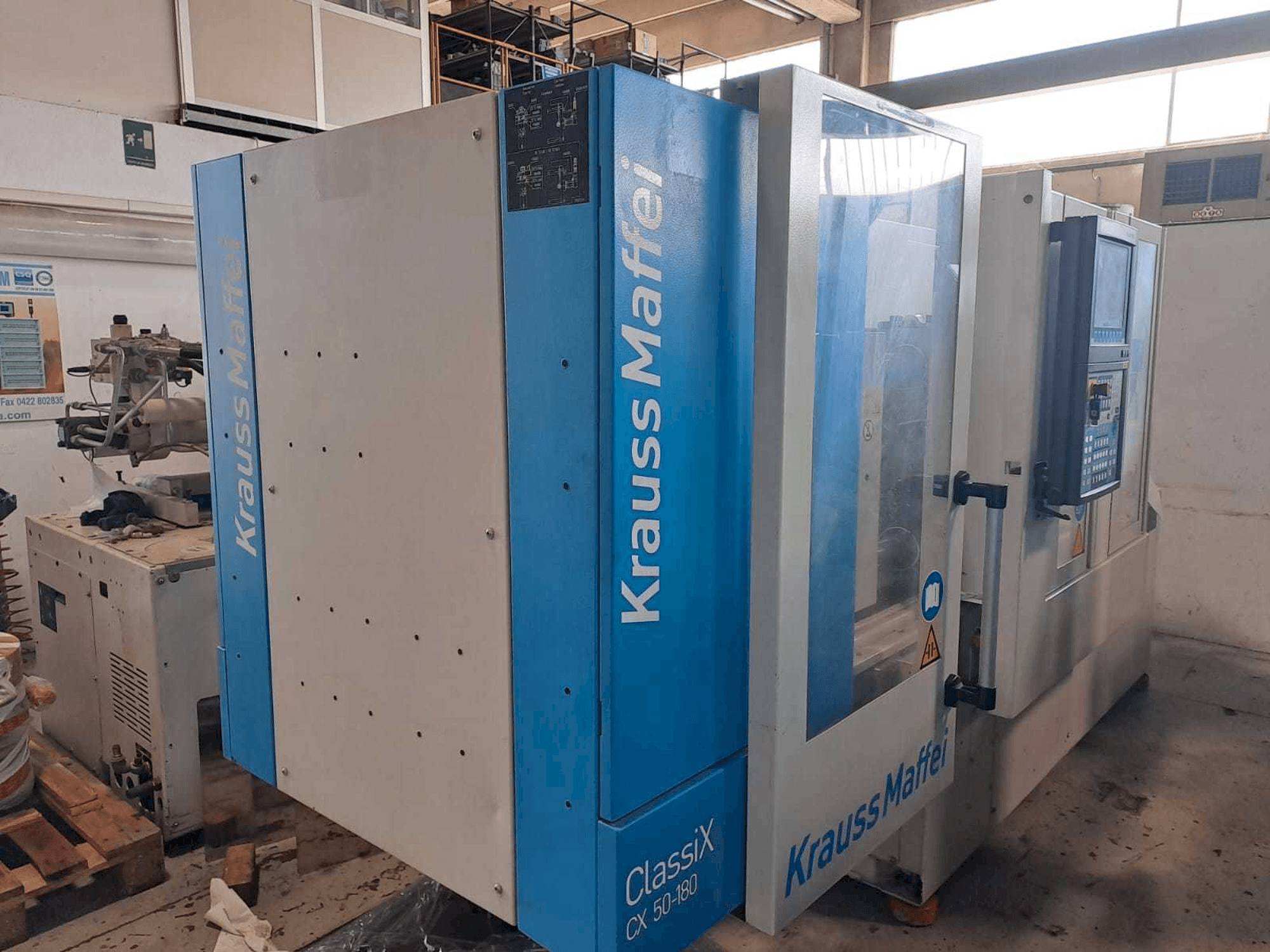 Krauss Maffei 50-180CX-maskinen sedd från vänster