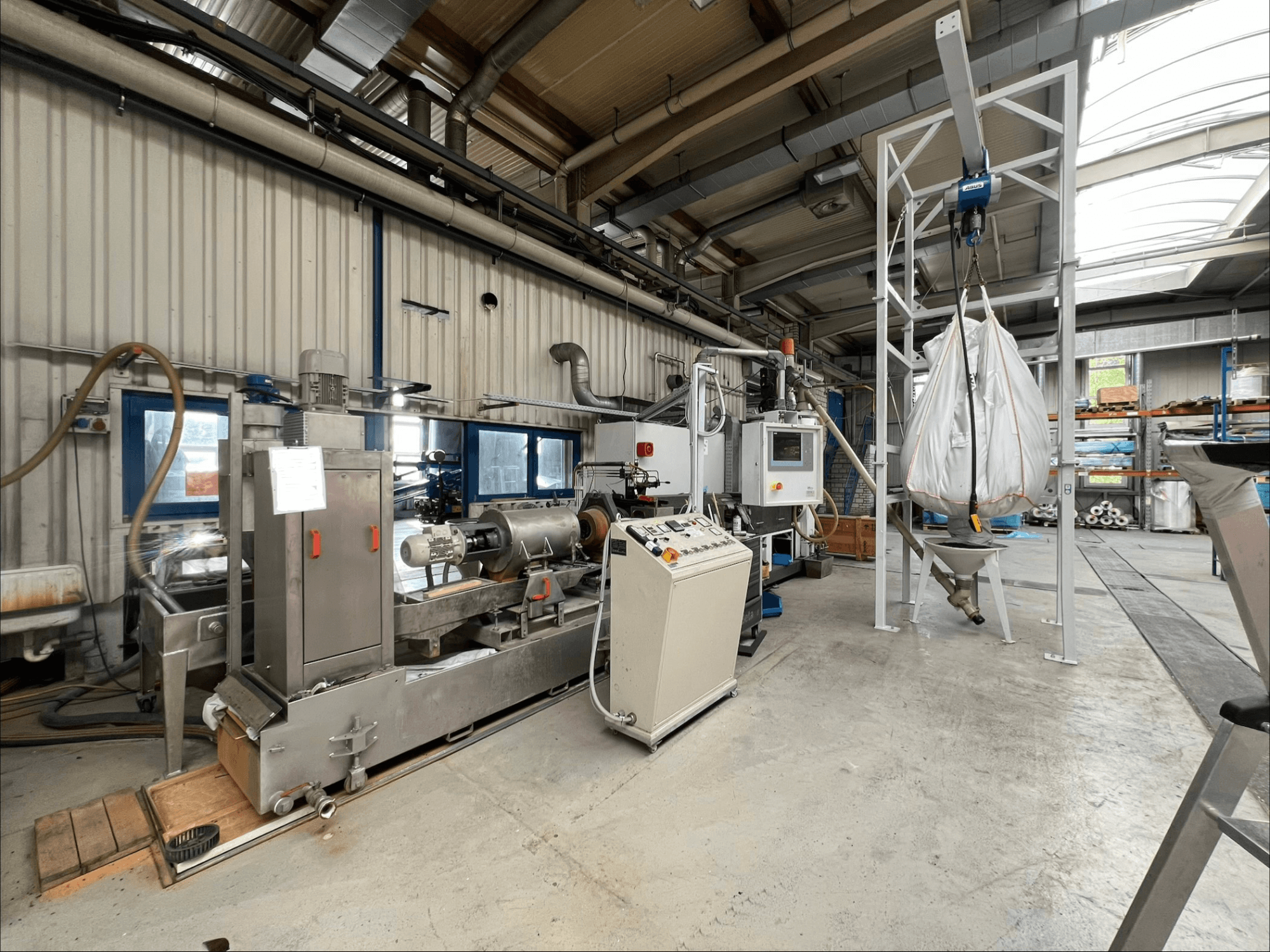 Framifrånvy av plastbearbetningsmaskinen FILTEC GRP 350 i en industriell miljö, med manöverpanel och matningssystem.