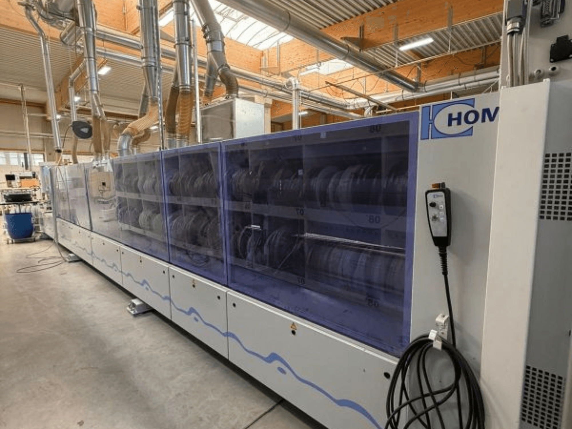 HOM industriell tvättmaskin, framifrån, med genomskinlig panel som visar disk; kontrollpanel med knappar på sidan.